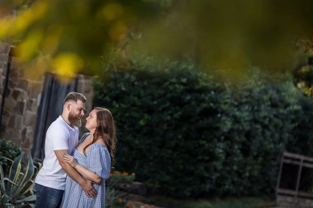 Lacey and Trey facing each other with blurred leaves across the upper foreground.
