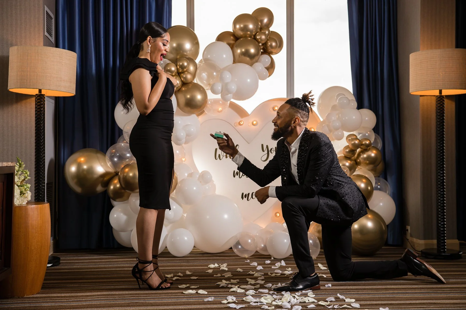 Surprise proposal inside a private suite with romantic proposal decorations
