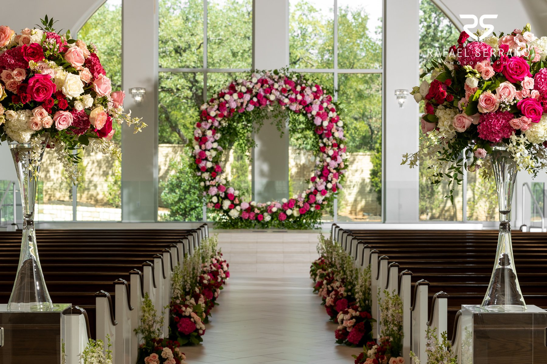 Elegant wedding ceremony with floral arch and aisle arrangements in Dallas, Texas.