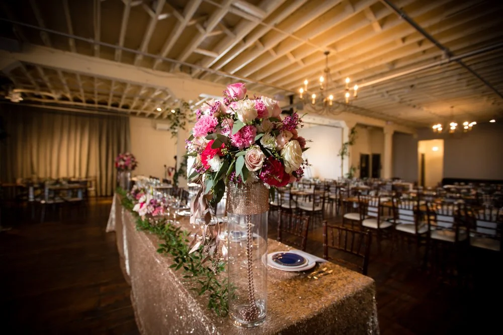 Wedding reception floral centerpiece and decorated tables inside The Brik in Fort Worth, Texas.
