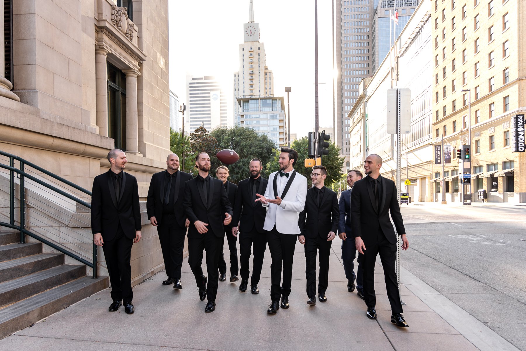 Groom and groomsmen walking through downtown Dallas before a wedding at The Room on Main