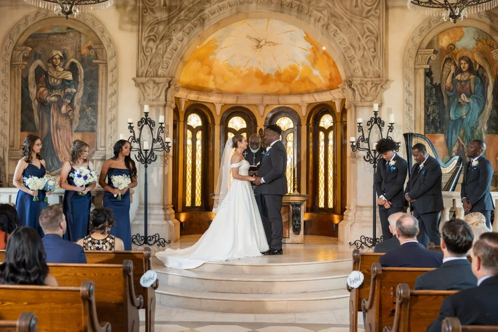 Mallory and Marcus facing each other at the altar during their wedding ceremony.
