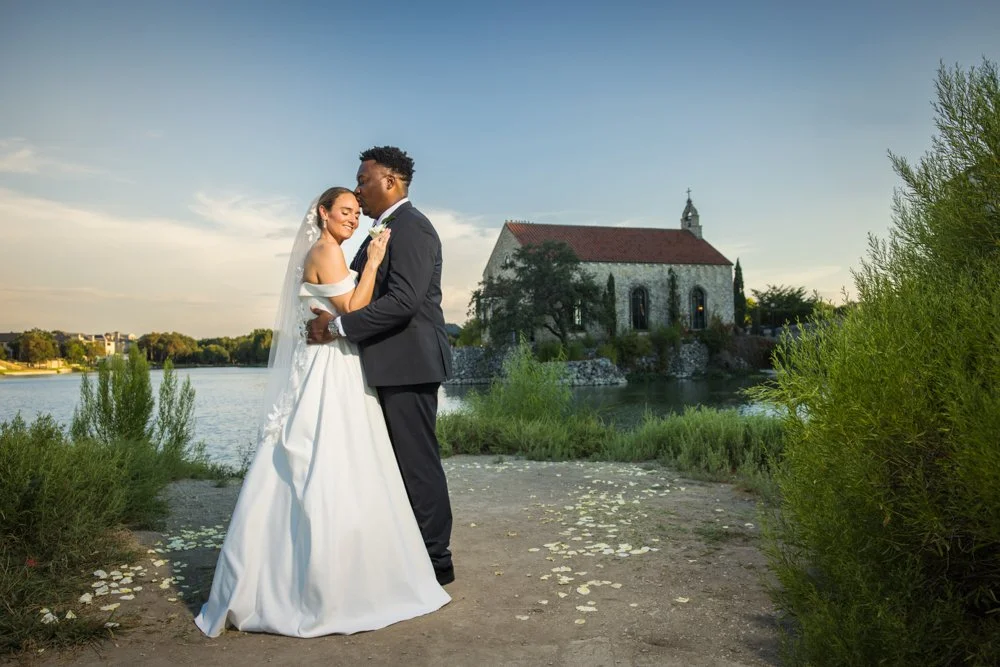 Mallory and Marcus beside the water with Bella Donna Chapel in the background.