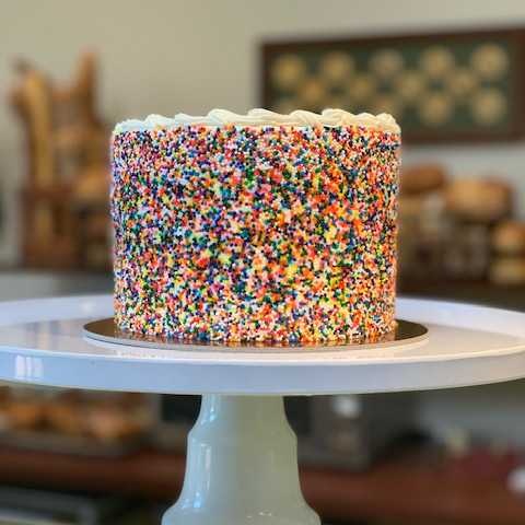 Wonder Cake Butter vanilla Cake with a Bavarian custard filling topped with buttercream frosting and rainbow sprinkles