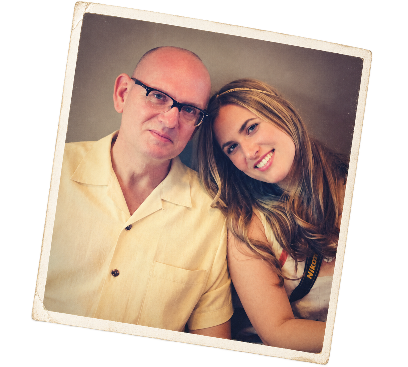 A man and young woman taking a selfie together, smiling, with the woman leaning her head on the man's shoulder.