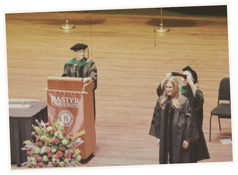 Graduation ceremony at Bostyr University with a student receiving her diploma and university officials present.