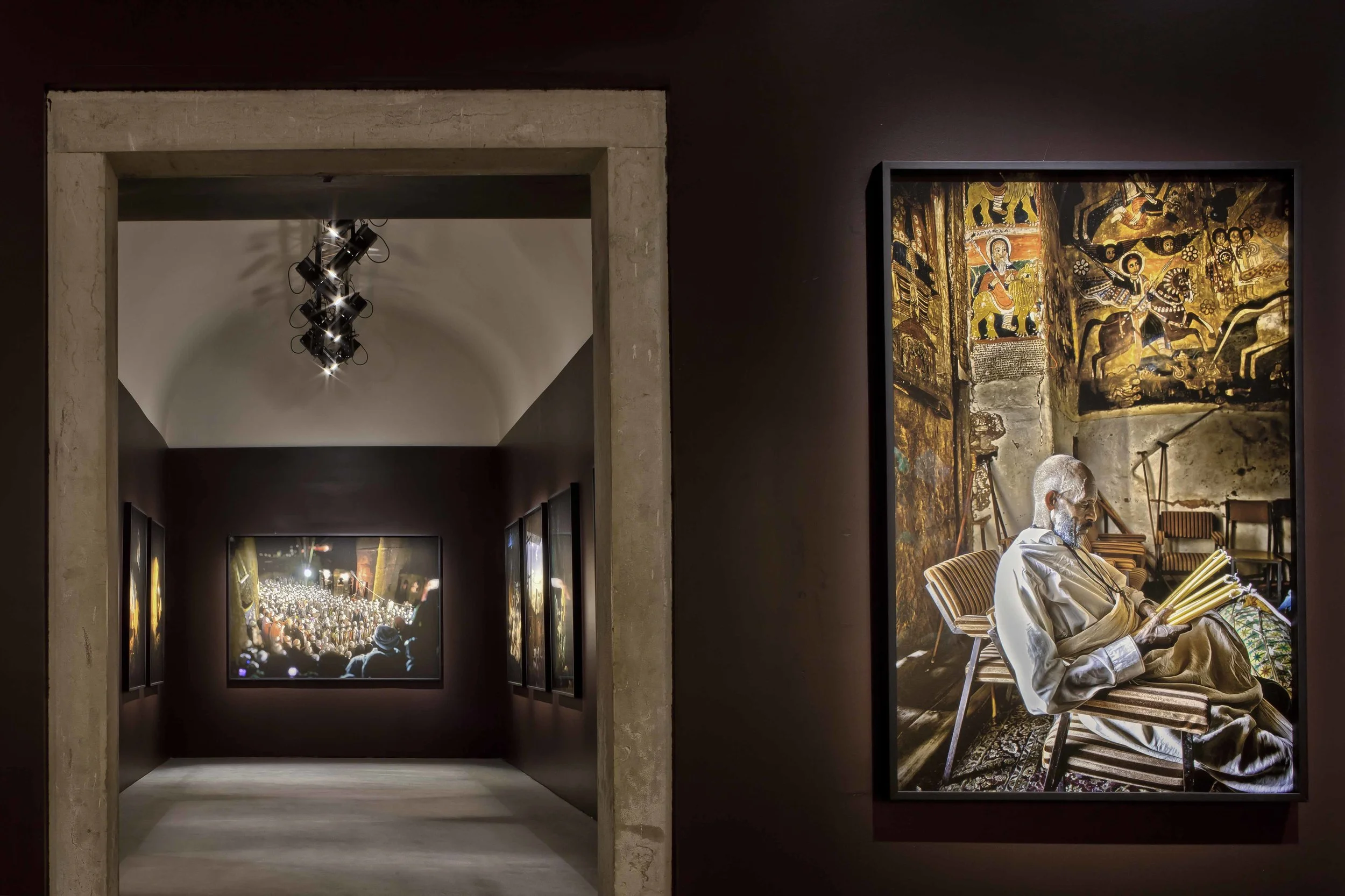 Mostra Fotografica Ethiopia Spiritual Imprints Abbazia di San Giorgio Maggiore, Venezia L’allestimento della mostra fotografica di Lizy Manola presso l’Officina del’Arte Spirituale nell’Isola di San Giorgio Maggiore, nasce da due obiettivi progettuali: armonizzare ogni foto con lo spazio, calibrando con cura lo sfondo che la incornicia; creare un’atmosfera suggestiva, capace di evocare la profonda spiritualità del popolo etiope. Una serie di interventi mirati hanno reso lo spazio essenziale, eliminando i dettagli superflui e razionalizzando il percorso fra gli ambienti. Si è rivelata così un’architettura pura, in cui opere diverse per intensità, luce e colore hanno trovato la loro giusta collocazione in cui un’accurata disposizione di luci e ombre, velate dal timbro terroso dello sfondo, esalta la viva suggestione del racconto fotografico. Data: 2014 Progettista: Paolo De Benedictis Collaboratori: Emina Gauzanovic, Maria Angilecchia Fotografa: Alessandra Chemollo << cambia progetto >>
