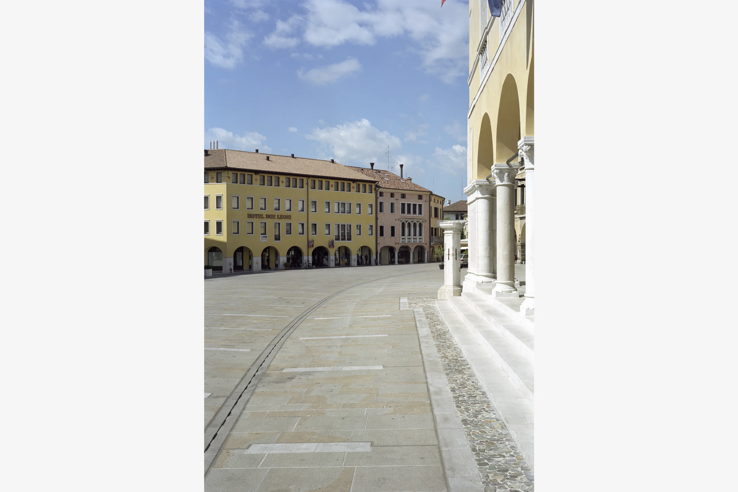 Piazza del Popolo, Sacile, Pn - Concorso primo premio Il progetto si sviluppa nel centro storico della città di Sacile; prevede la riqualificazione di Piazza del Popolo e degli spazi marginali che ne costituiscono l’affaccio sul fiume Livenza. L'idea è quella di sovrapporre su tutto l’invaso una "pelle" che si misura con il sito e con le preesistenze, asseconda l'andamento del suolo e media il dislivello tra i portici. Gli spazi che si affacciano sul fiume mantengono la propria identità fisica data da dimensioni e confini, ma ripropongono un nuovo rapporto con l’acqua individuando delle zone di sosta a diretto contatto fisico e visivo con l’acqua. Sotto i portici l’intervento si è limitato alla conservazione delle pavimentazioni più antiche e di tutte le pietre di pregio. Questi ultimi sono stati integrati nelle nuove pavimentazioni. Data: 1999 | 2011 Progettisti: Paolo De Benedictis, Sara Lonardi, Enrico Maria Raschi Progettista impianti e strutture: Luca Pulignano Collaboratrice: Emina Gauzanovic Fotografo: Marco Introini 2003 Mostra internazionale “Nib+Icar Traveling 2004” Progetto Segnalato 2010 Premio Marcello D’olivo - Rassegna Biennale di Architettura Progetto Segnalato 2010 Premio IQU – Innovazione e qualità urbana Secondo premio nella sezione opere realizzate << cambia progetto >>