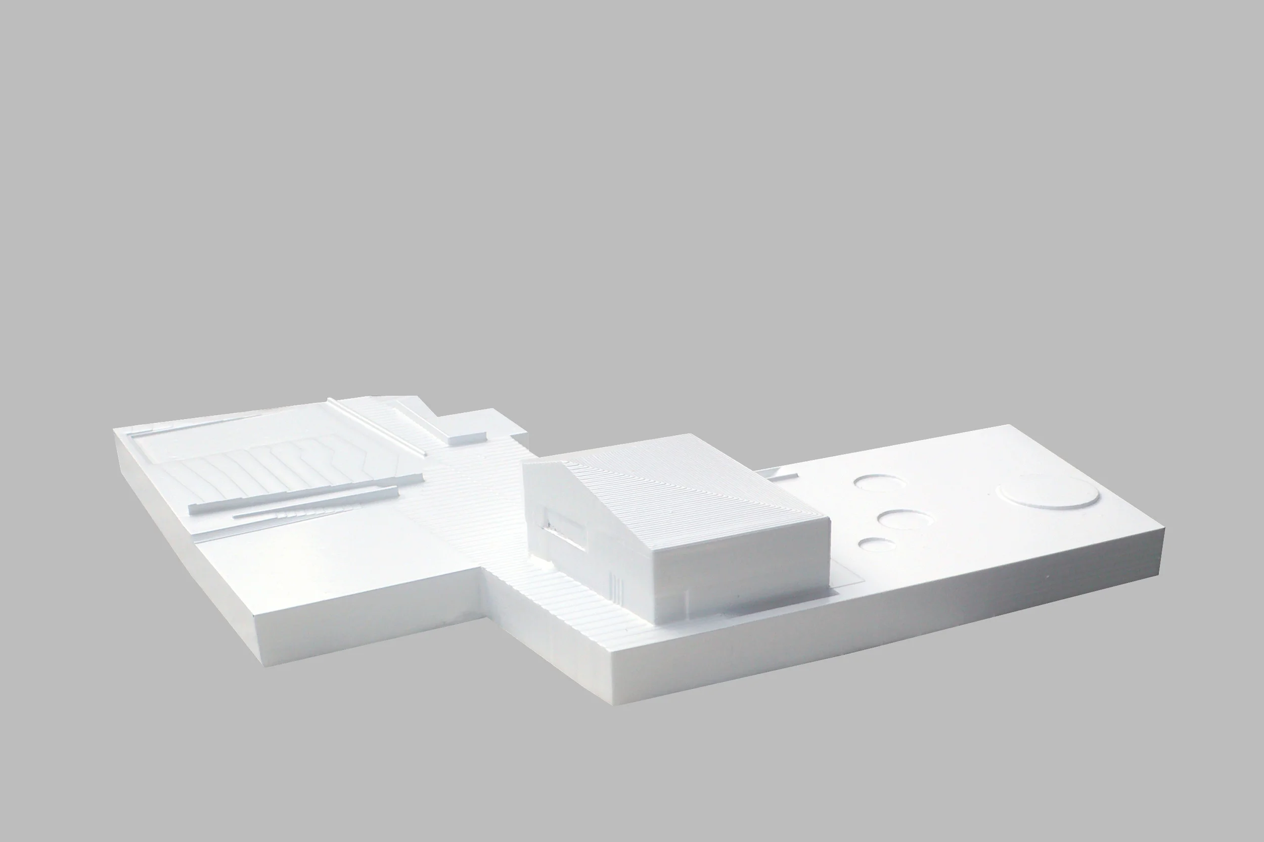 Kindergarten e Music Reharsal Hall, Sluderno, Bz The building for this design competition was conceived as a monolithic bloc positioned on the edge of the project area in the centre of a small town in Val Venosta. The volume has alignments that are meant to create a complex system of public spaces where the relations between the buildings and the surrounding environment are clearly marked. Through a slight asymmetry on the façade, a minimal roof deformation, and calibrating the height of the eaves, the project proposes a simple and yet dymanic volume as the core of a wide range of surrounding public spaces. The building’s civic character is expressed through three openings that create some permeability between outside and inside and bring public and gathering functions to the façade. At the rear, the façade takes a more private character and a smaller scale. The alignment of the outside volume reach inside the building, defining the different spaces and producing a succeding ensemble of dynamic spaces that multiply the visual connections between the various rooms. Project (Competition) Date: 2012 Architects: Paolo De Benedictis, Adolfo Zanetti Assistants: Andrea Cremasco, Emina Guazanovic, Mark Sonego << change project >> 