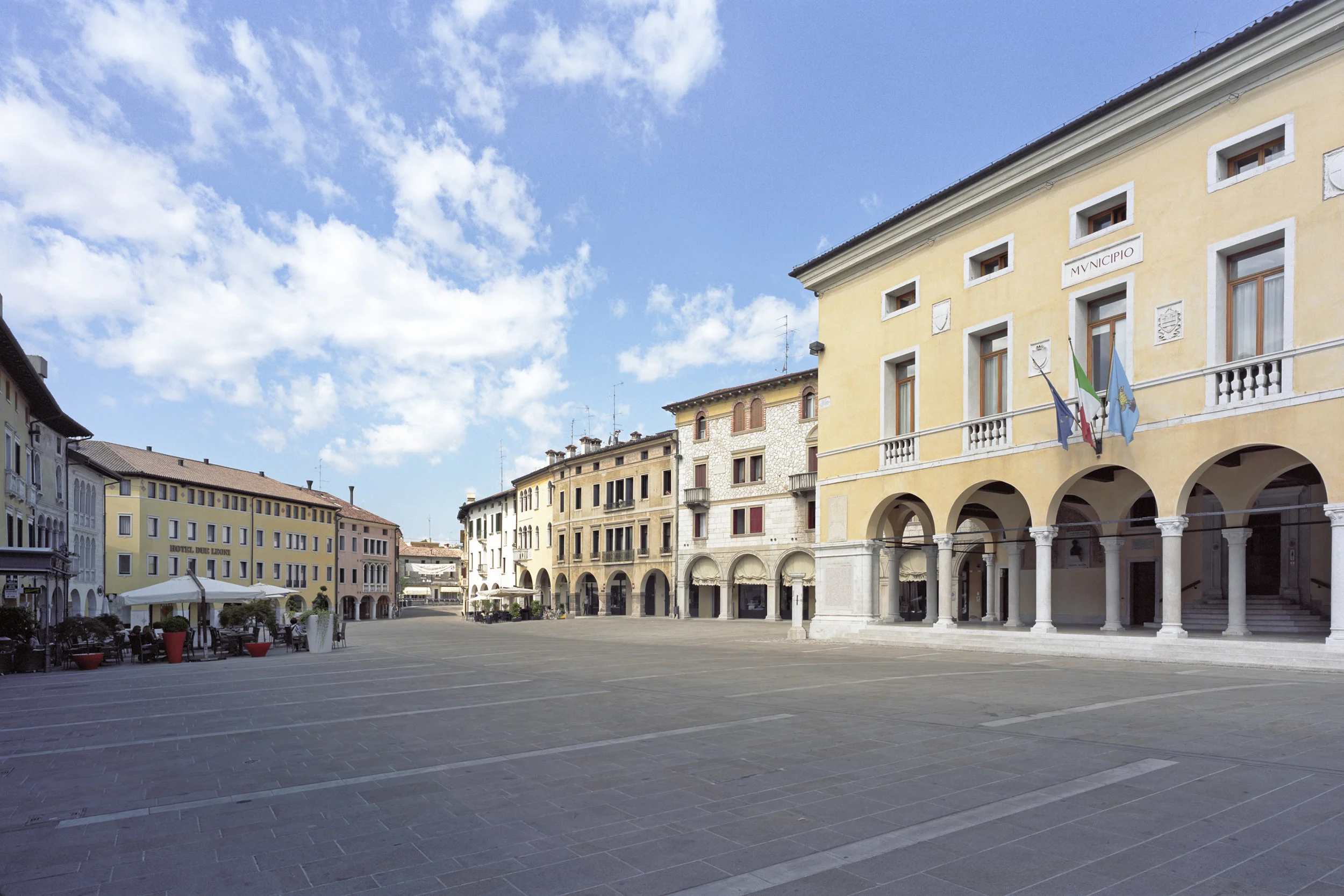 Piazza del Popolo, Sacile, Pn - Competition first prize The project develops in the historic centre of the town of Sacile (Pn); it involves the renovation of the People’s Square and of its surrounding spaces that overlook the Livenza River. The idea was to lay upon the whole square’s area a “coat” that comes into relation with the site and the pre-existing spaces, going along with the soil trend and balancing the difference in height of the portico. The spaces overlooking the river maintain their original physical identity which is marked by size and boundaries, but establishes a new relationship with water by creating rest areas that have direct physical and visual contact with the water. Under the portico, the project preserved the old floor and all the valuable existing stones. The latter were integrated into the new flooring. Date: 1999 | 2011 Architects: Paolo De Benedictis, Sara Lonardi, Enrico Maria Raschi Service Engineer: Luca Pulignano Assistant: Emina Guazanovic Photography: Marco Introini 2003 International exhibition “Nib+Icar Traveling 2004” Special Mention 2010 Marcello D’olivo Prize- Biennale of Architecture Special Mention 2010 IQU Prize – Innovation and urban quality Second prize in the executed project section << change project >>