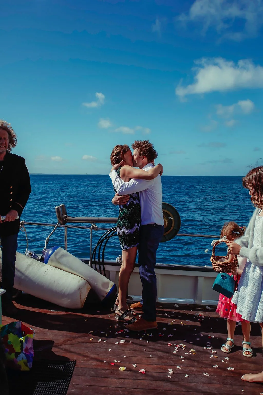 bride and groom kissing near the ocean