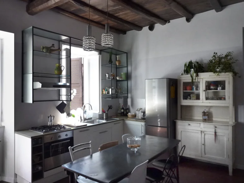 La zona pranzo, con il pensile in metallo e vetro che incornicia la finestra
