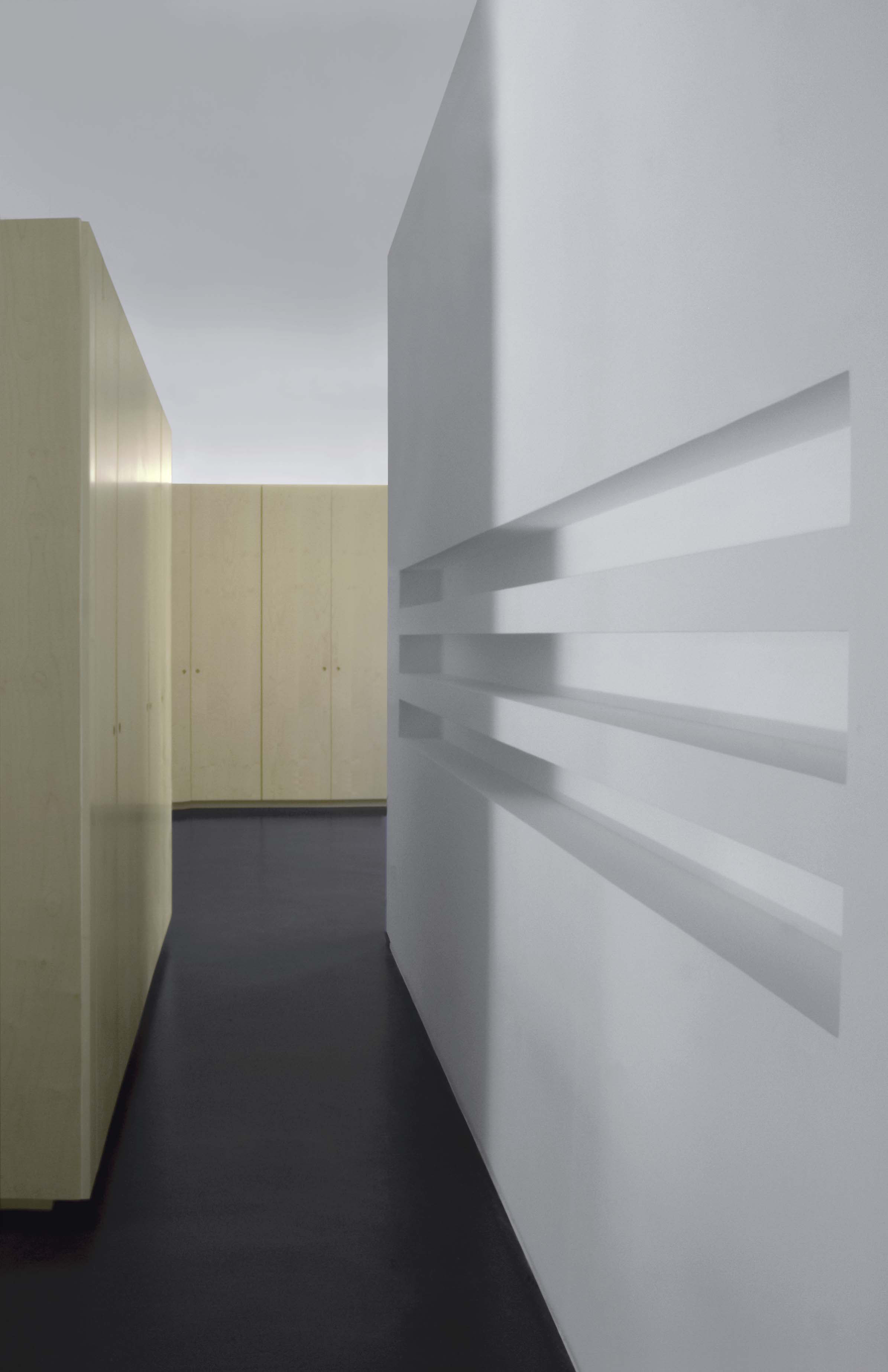 L'ingresso, con i bliocchi di arredo in legno che organizzano la casa e tre grandi nicchie per i CD ricavate nella parete.