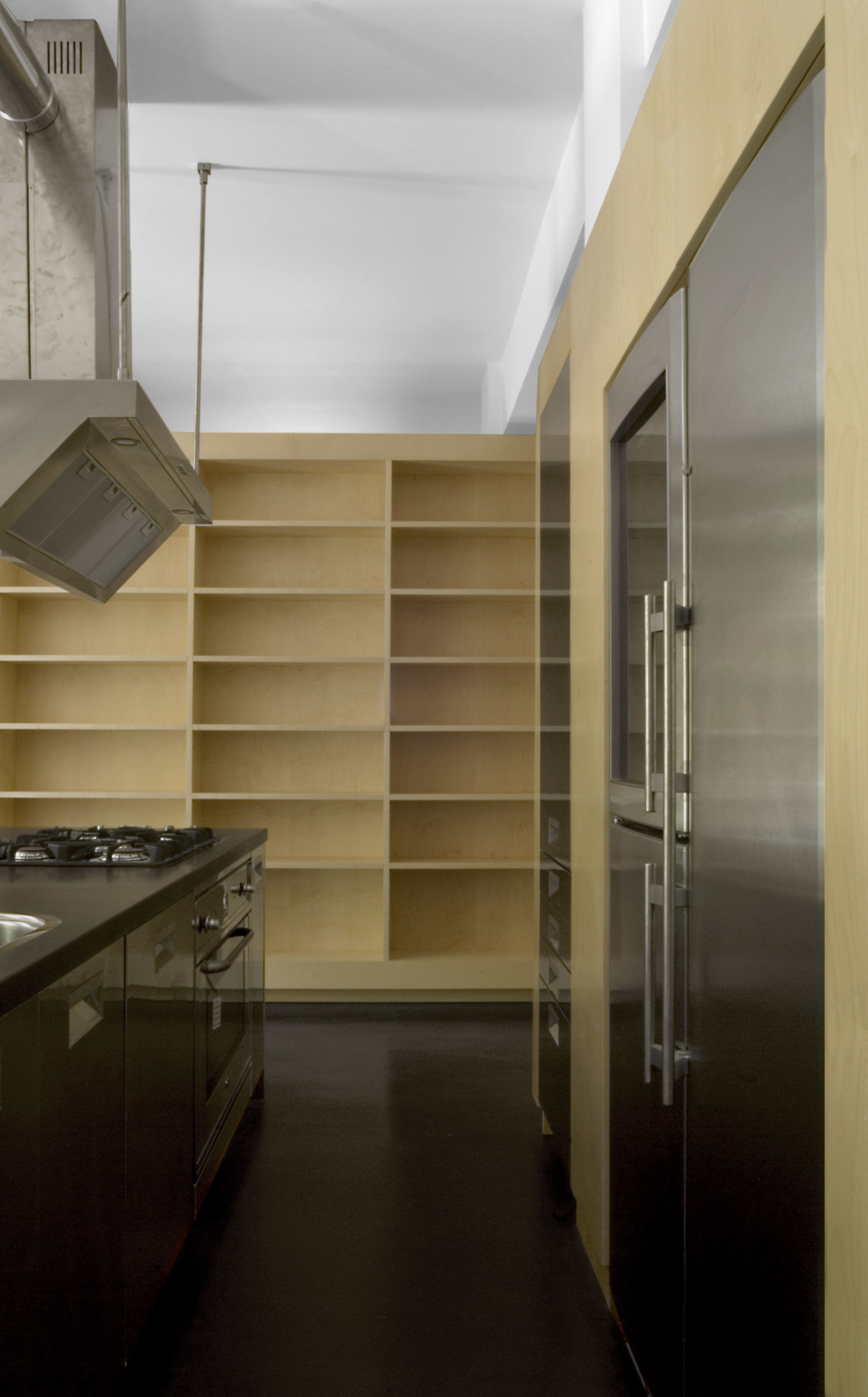 Il centro della casa, la cucina, con lo sfondo della libreria che la separa dalla zona notte.