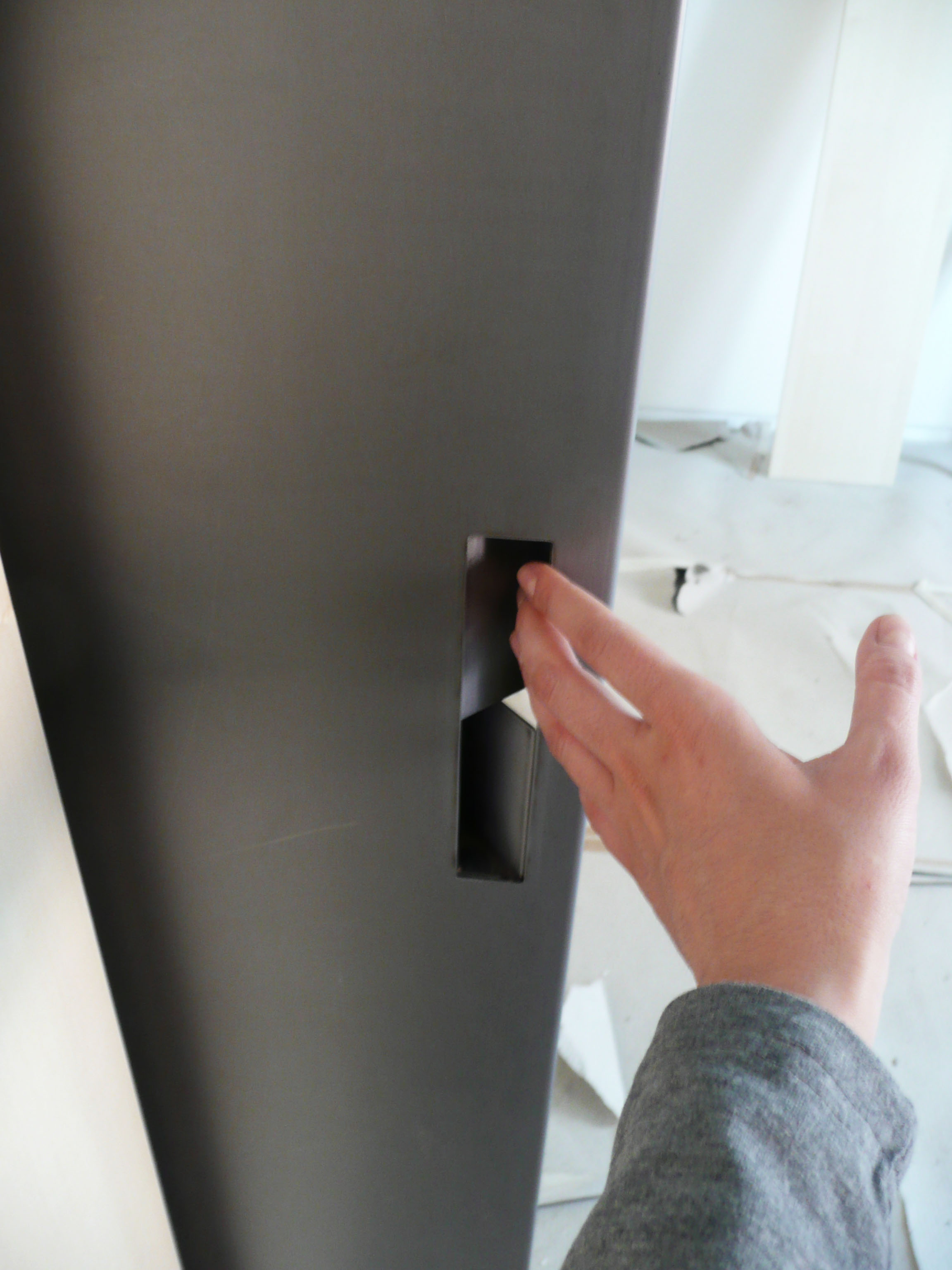 La maniglia della porta in metallo, realizzata con la lamiera di ferro piegata.