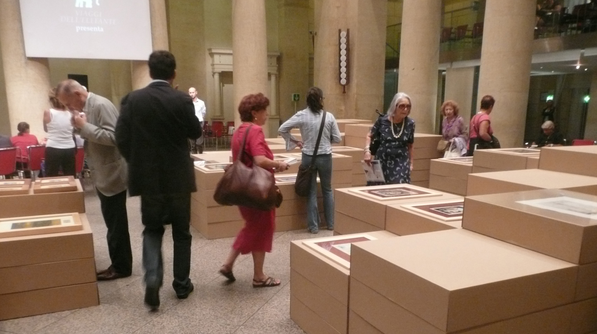 L'allestimento realizzato, con le opere poggiate sui volumi in cartone a diversa altezza in base alla dimensione, per favorirne l'osservazione.