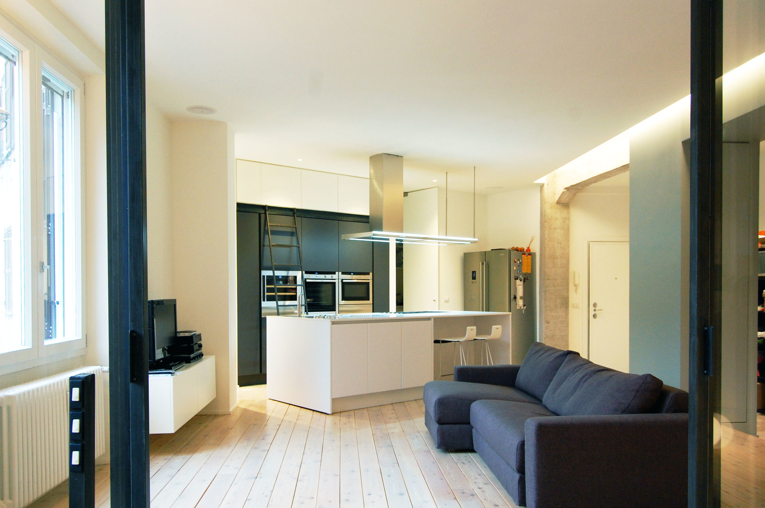 La zona living e, sullo sfondo, l'isola della cucina, riprese dallo studio.