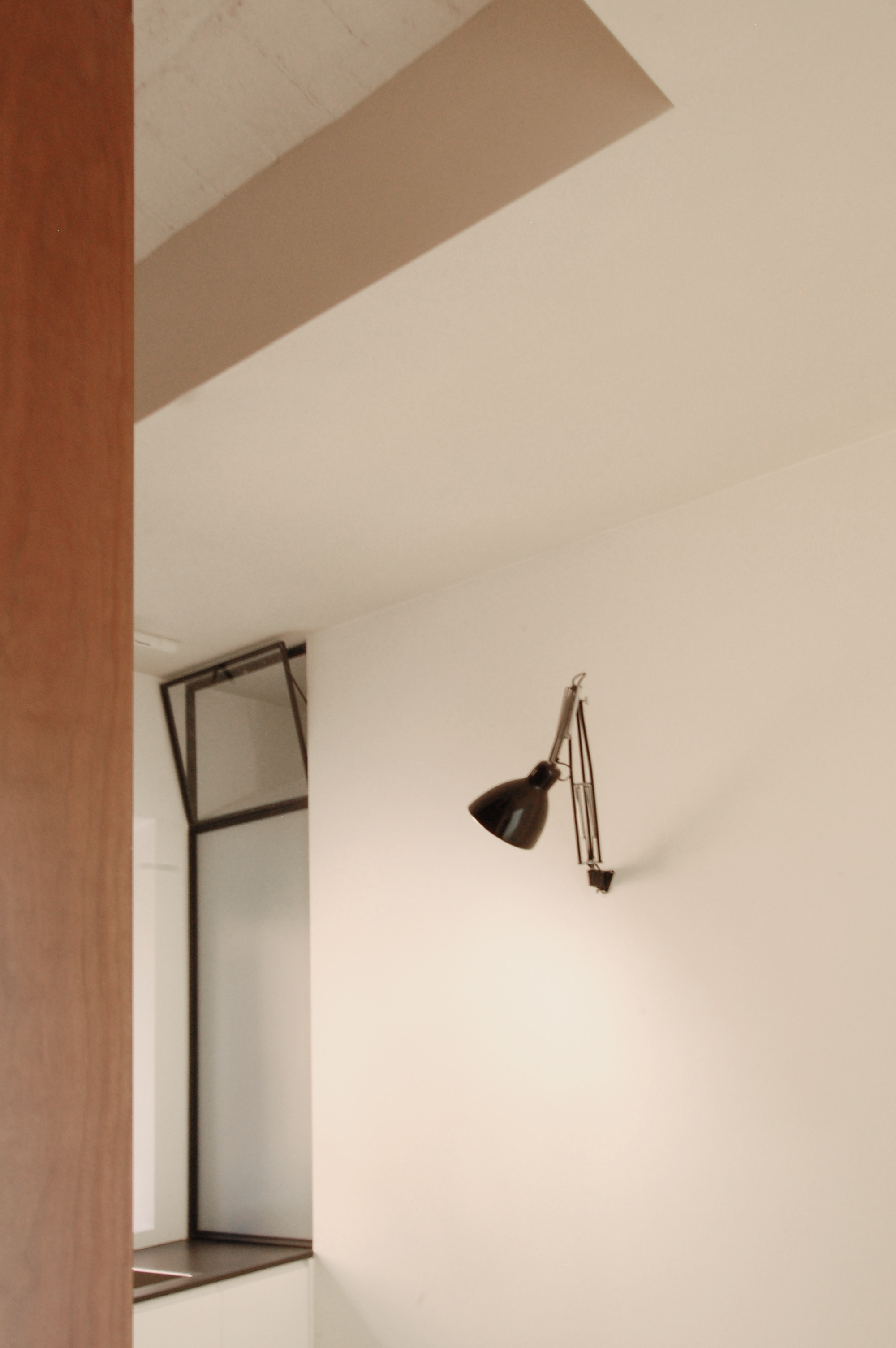Immagine di dettaglio, con la sottile superficie vetrata a separare doccia e cucina e assicurare luce naturale al bagno.