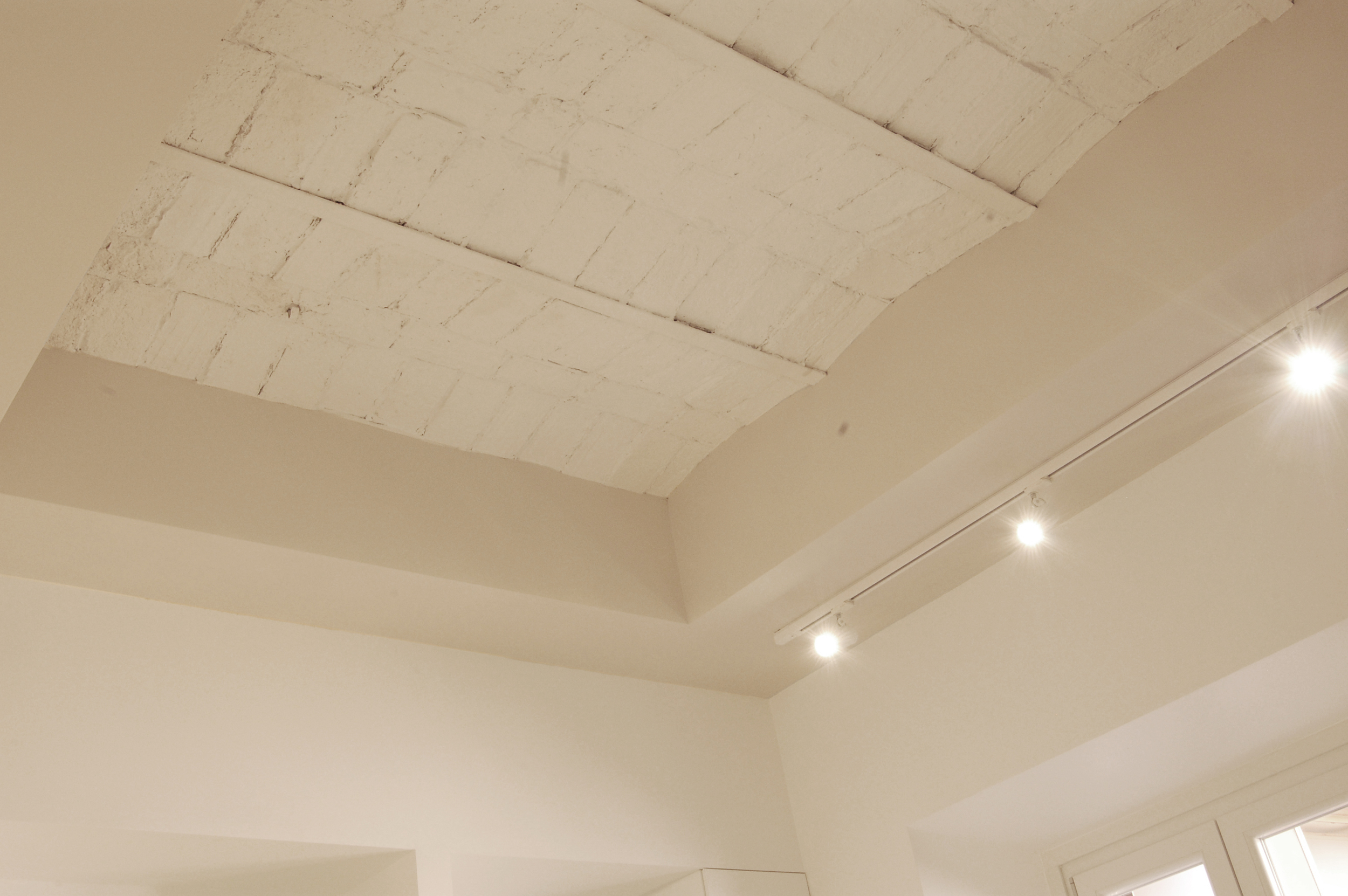 Immagine di dettaglio, con il soffitto a voltine riportato alla luce e posto in risalto dalla scelte cromatiche.