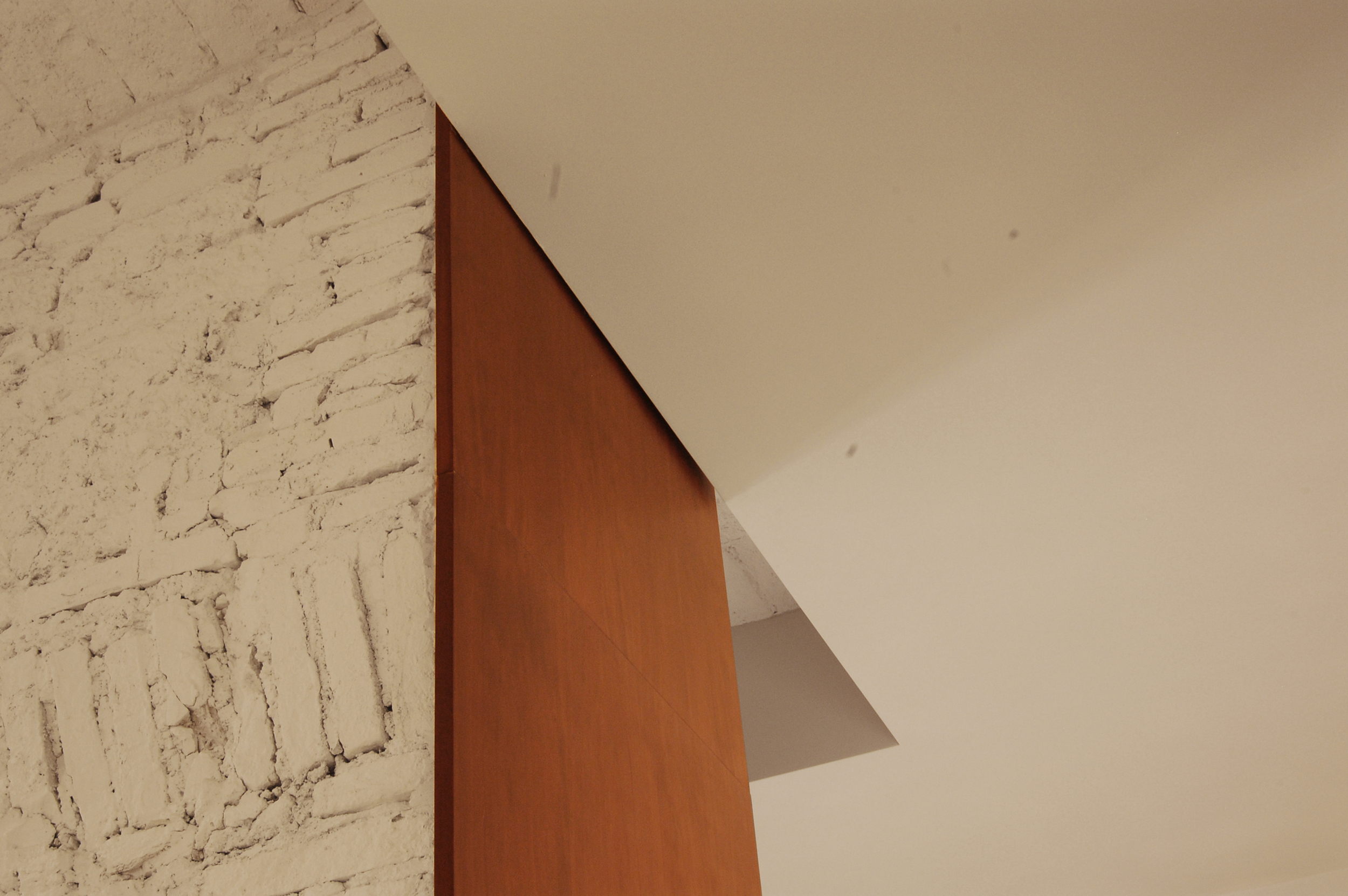 Immagine di dettaglio: geometrie rigorose e materiali caldi per una eleganza discreta.