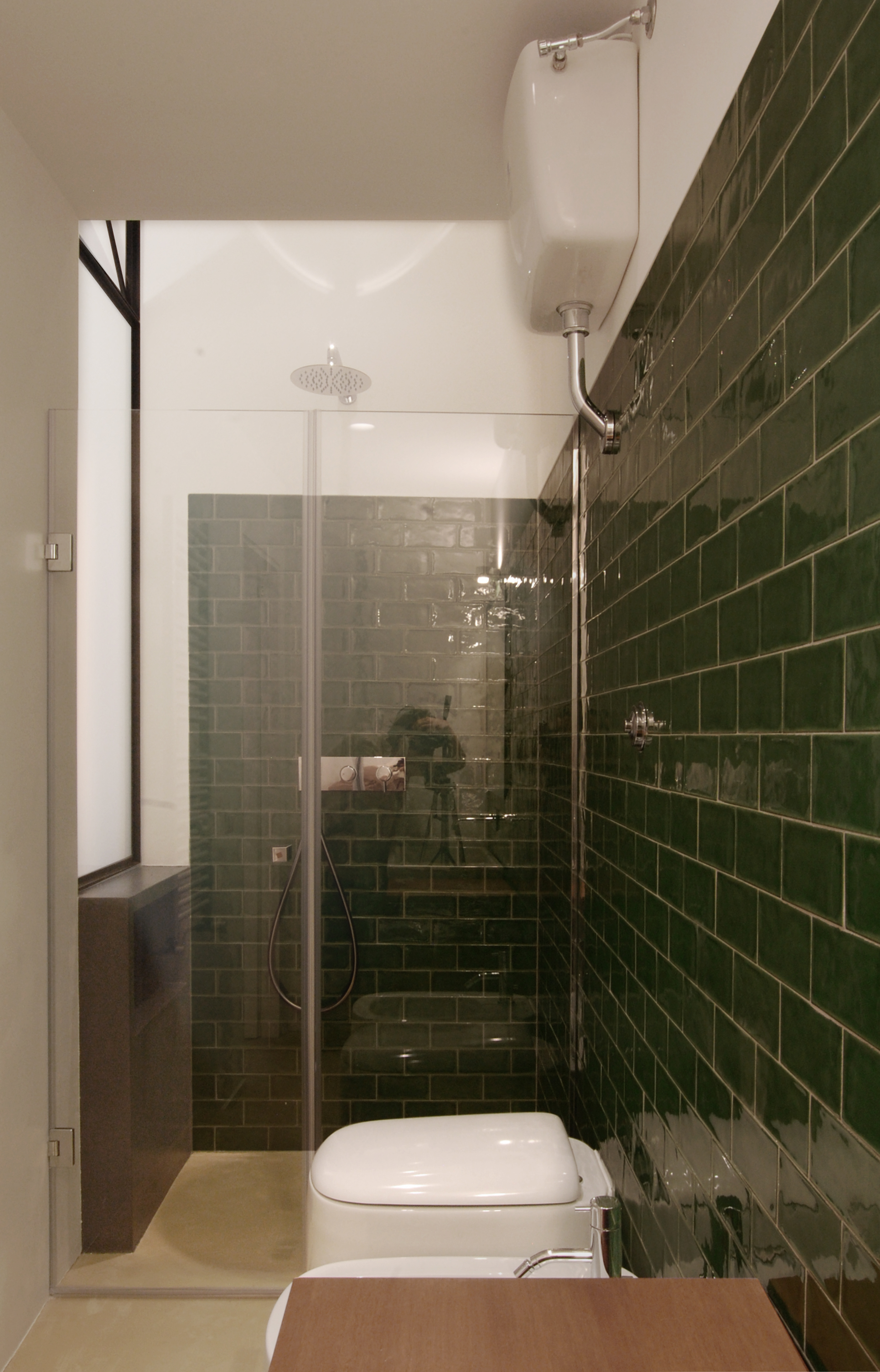 Il bagno, con la luce naturale assicurata dall'apertura vetrata e la cucina che penetra nella doccia, a ricavare lo spazio per i saponi.