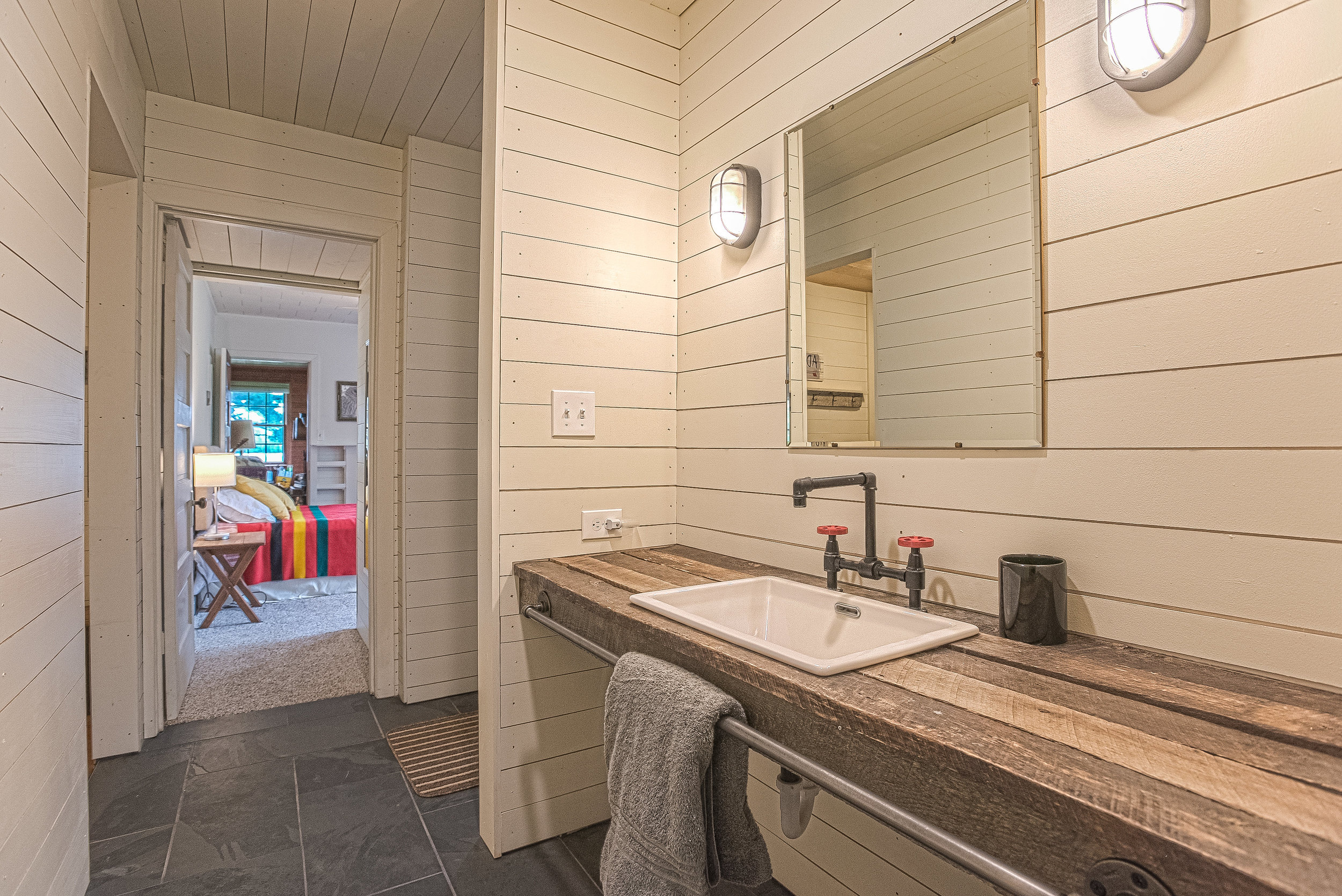 View into guest bedroom and living room from guest bathroom.