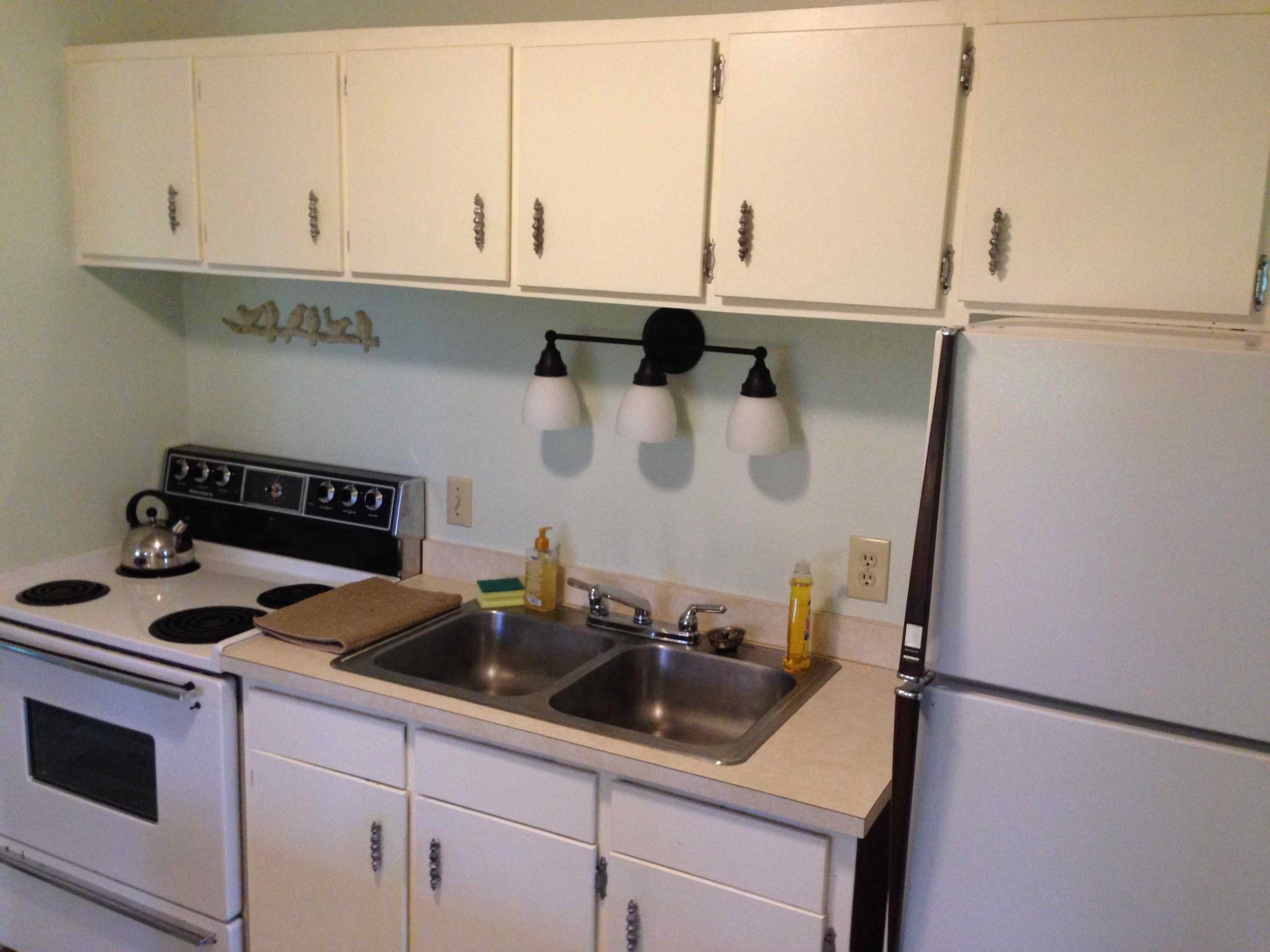 Little house fridge, stove and sink area.