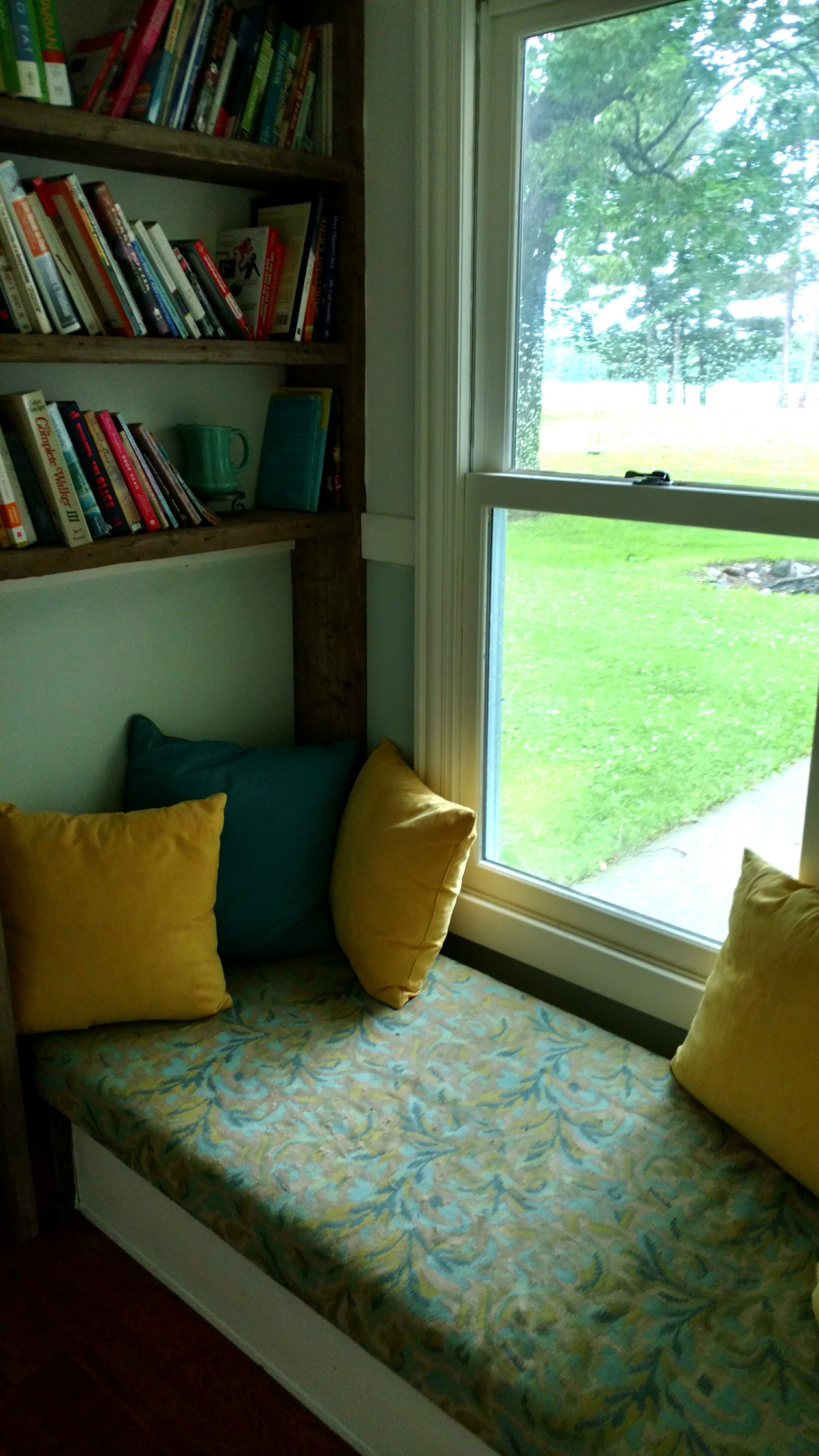 Little house entry foyer with comfy bench, mini-library, and oversized window overlooking the north fire pit, expansive lawn, volleyball court and Sugar Lake.