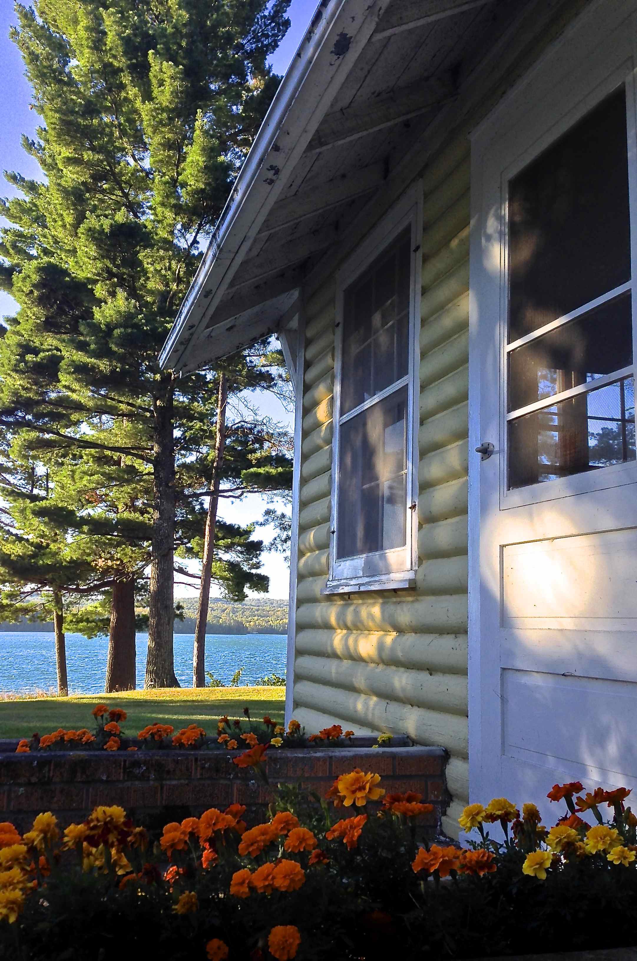 Flower lined, screen door entry into main house living room with spectacular views of Sugar Lake.