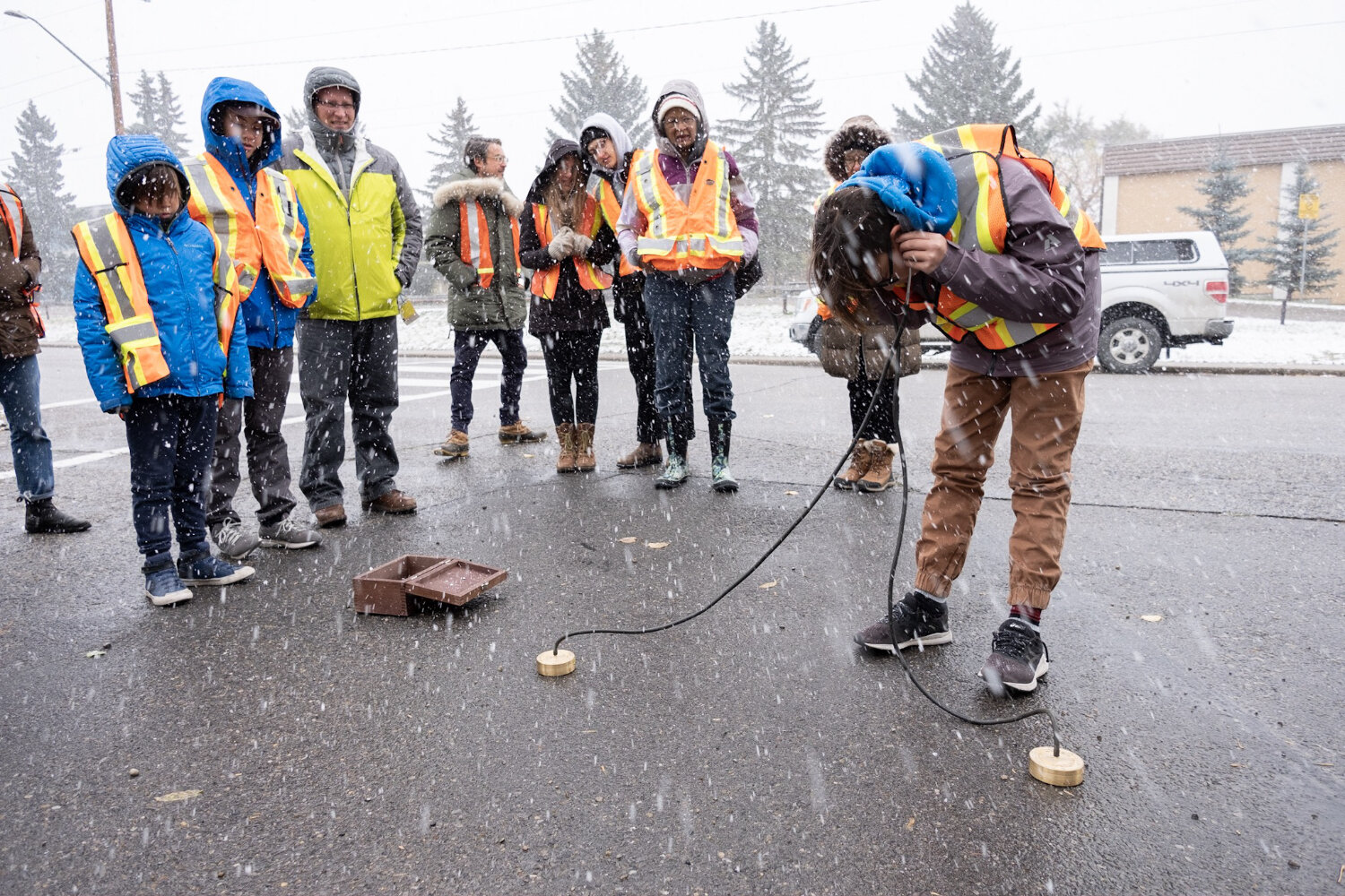  Participants of Becky Shaw's guided tour utilized a geophone to listen to running water deep beneath the city streets.   Photo by Jeffrey Heyden-Kaye 