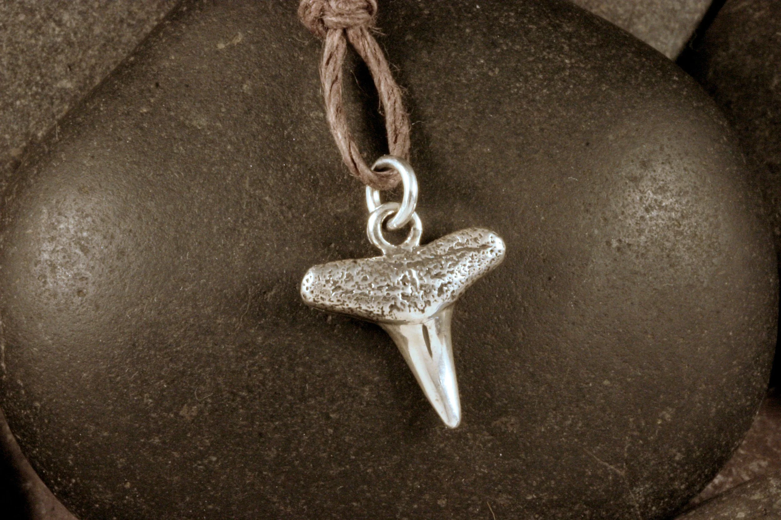 An oxidized sterling silver shark tooth charm.