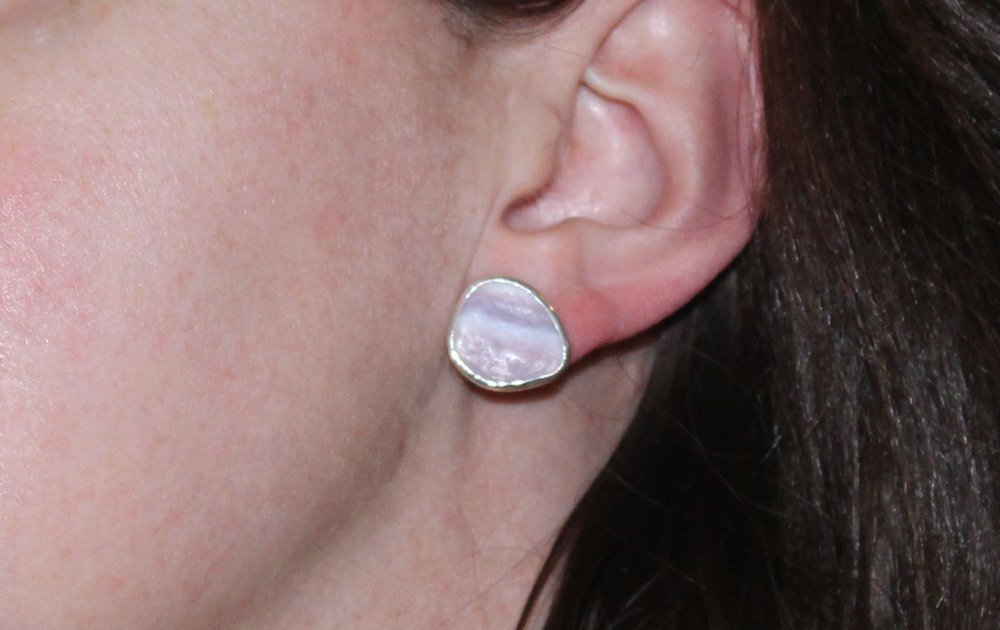 A model wearing sterling silver large sterling silver pentagon wampum studs.