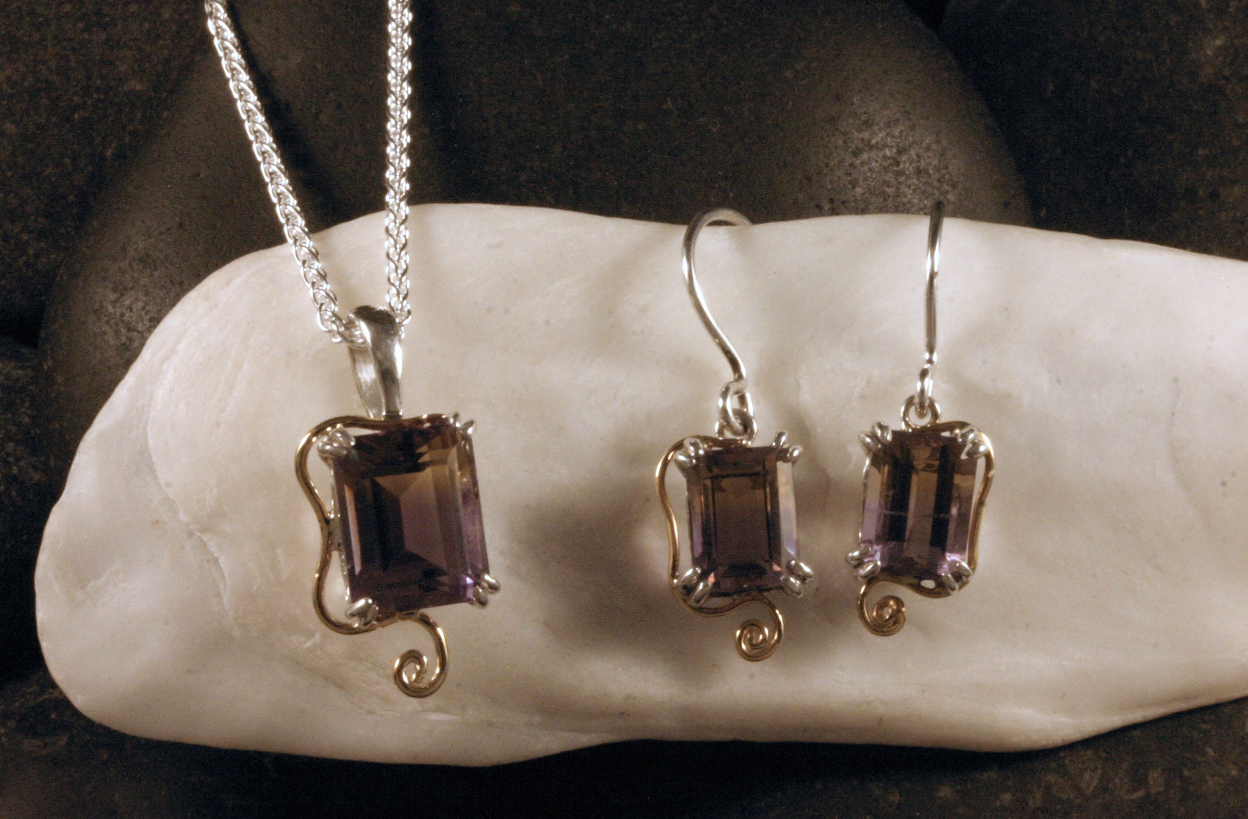 A matched jewelry set of a sterling silver & 14K gold ametrine pendant & dangle earrings.