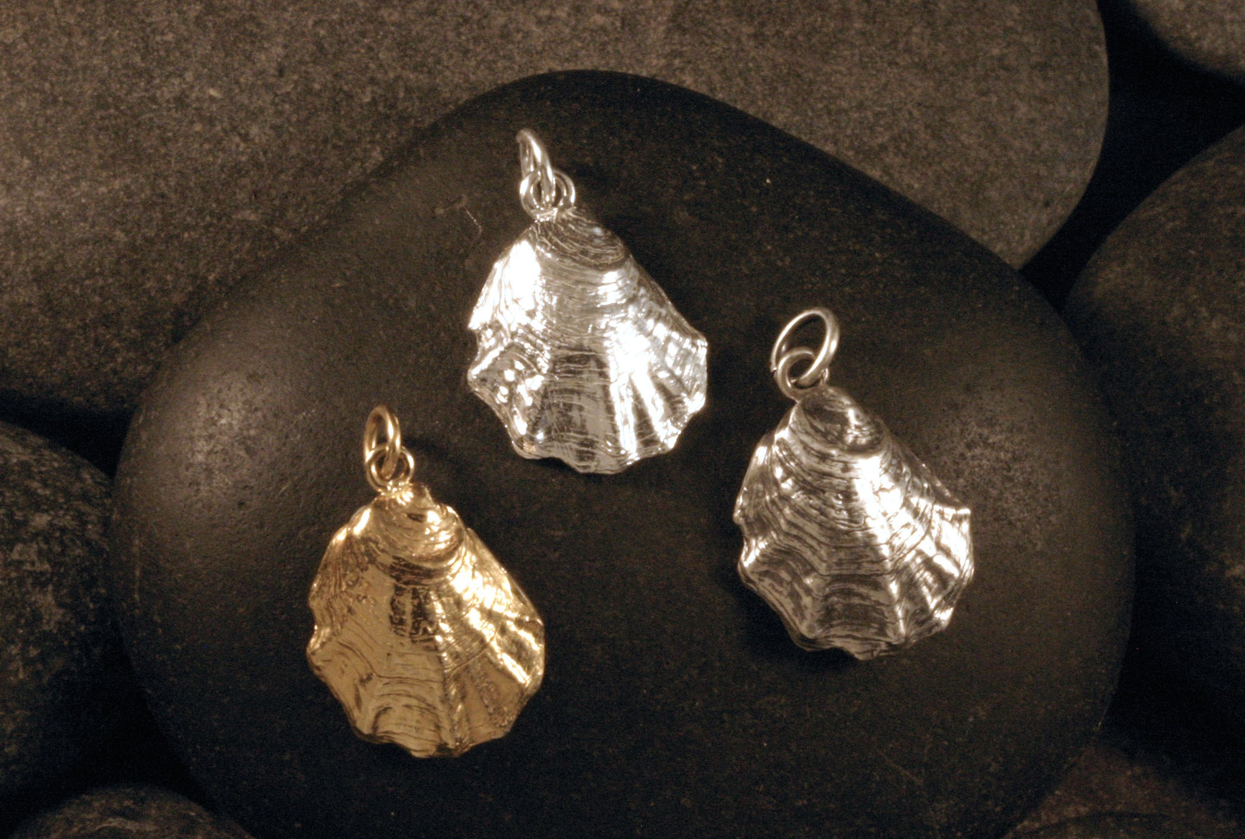Three small Wellfleet oyster shell charms in 14K gold, shiny sterling silver and oxidized sterling silver.