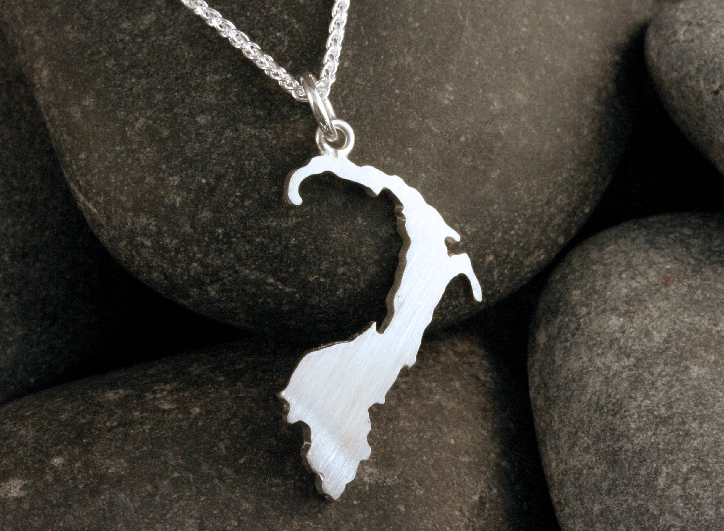 A large sterling silver Cape Cod map pendant.