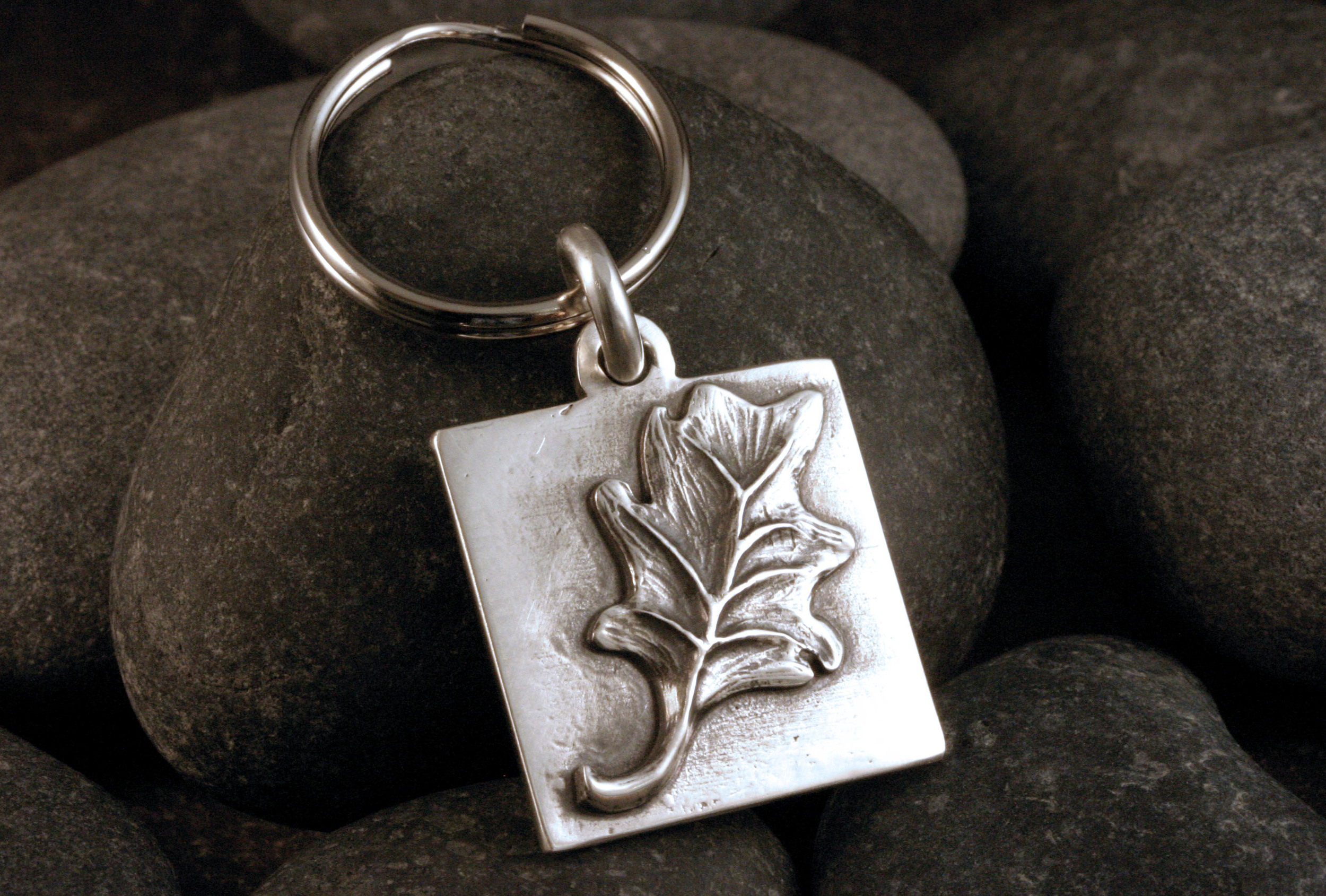 A hand carved sterling silver leaf keychain.
