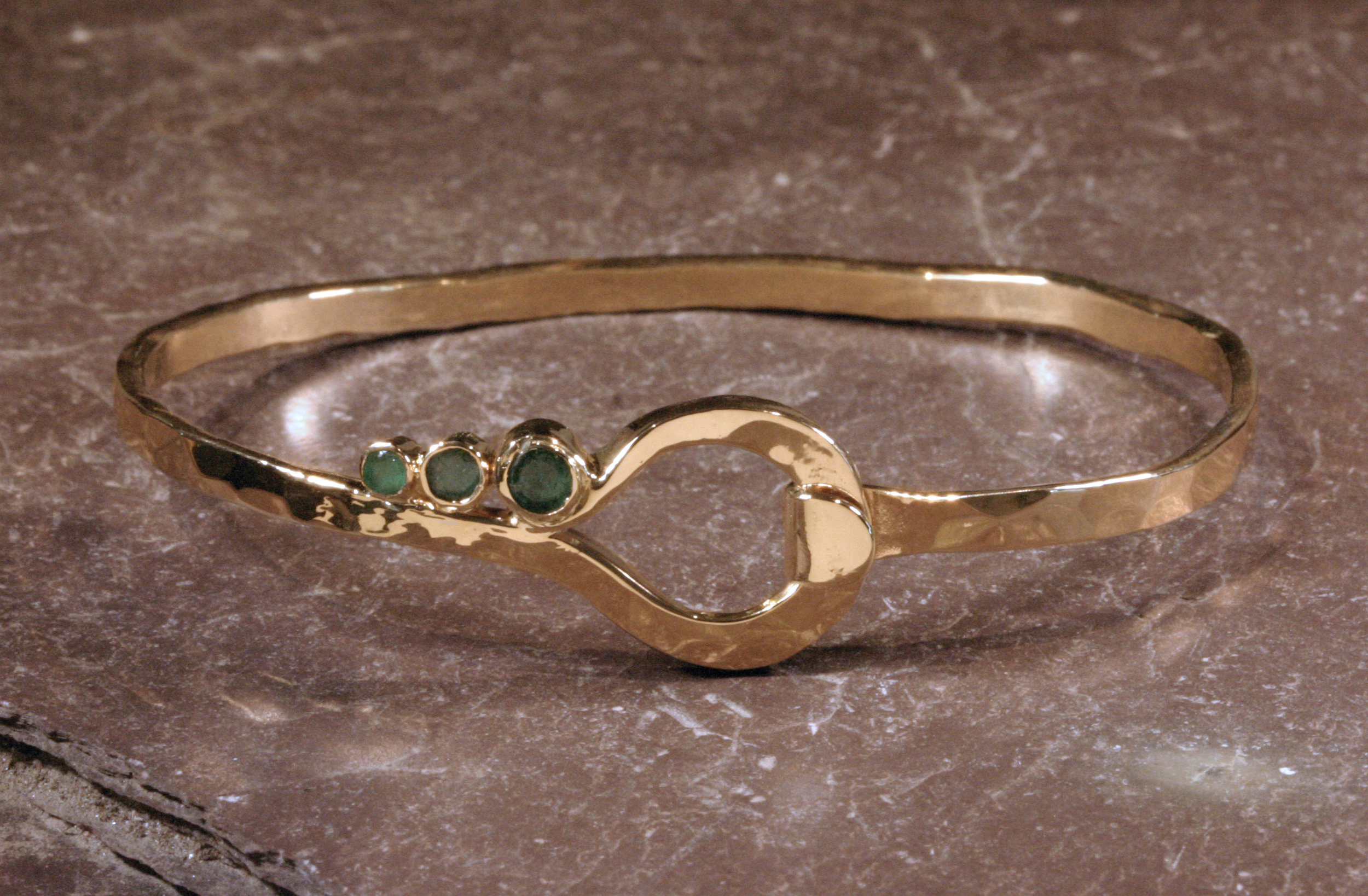 14K gold shepherd hook bracelet set with customer's emeralds.