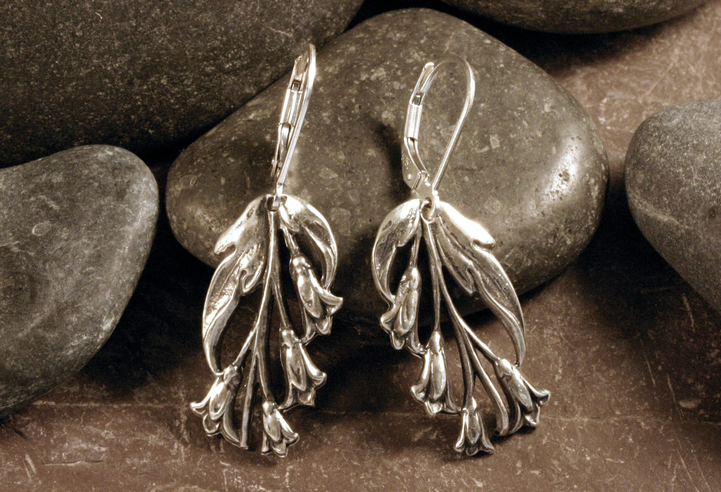 Sterling silver morning bell flower earrings on a rock