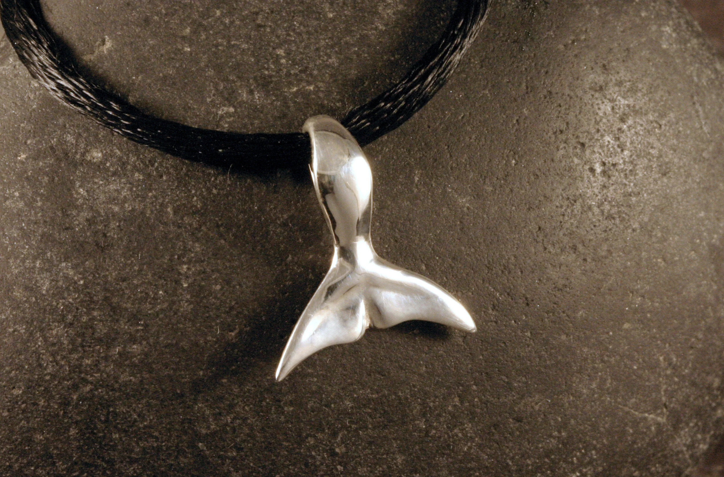 Small sterling silver whale tail pendant.