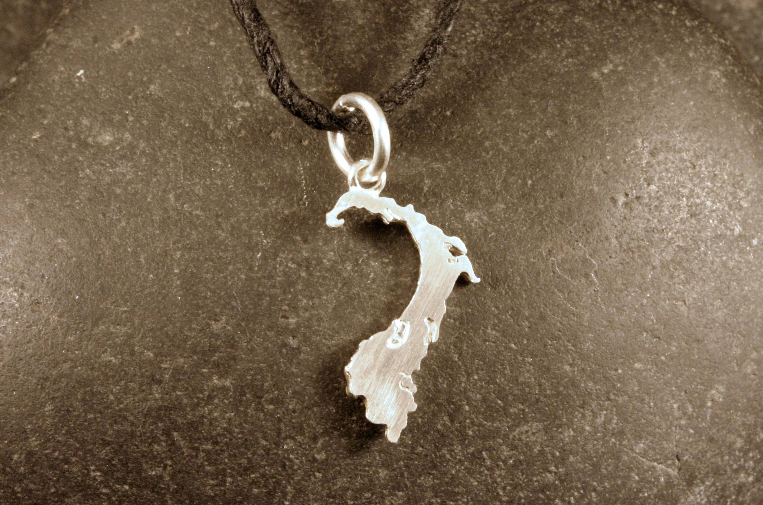 A small sterling silver Cape Cod map charm.