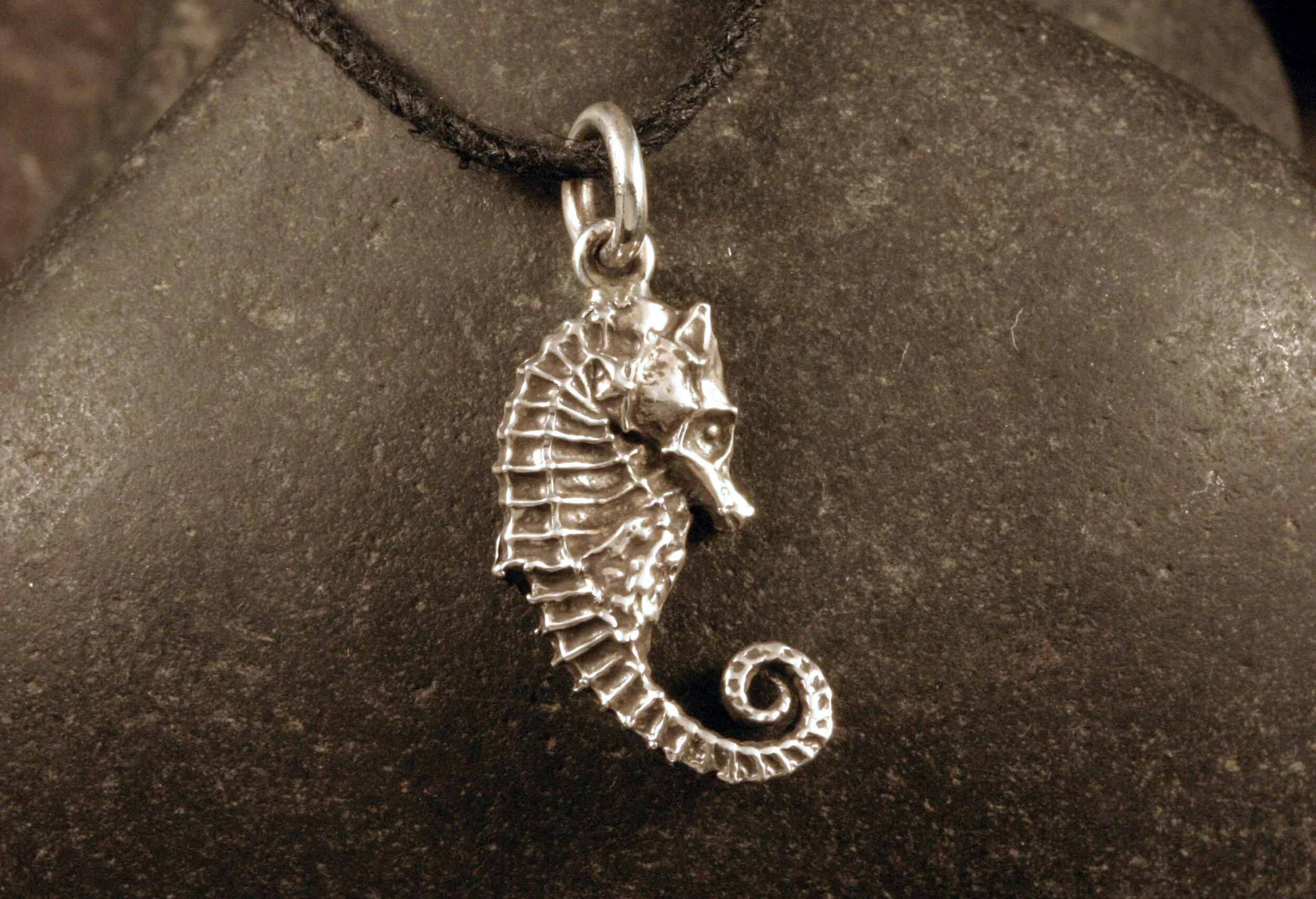 Right side view of oxidized sterling silver seahorse with curled tail charm
