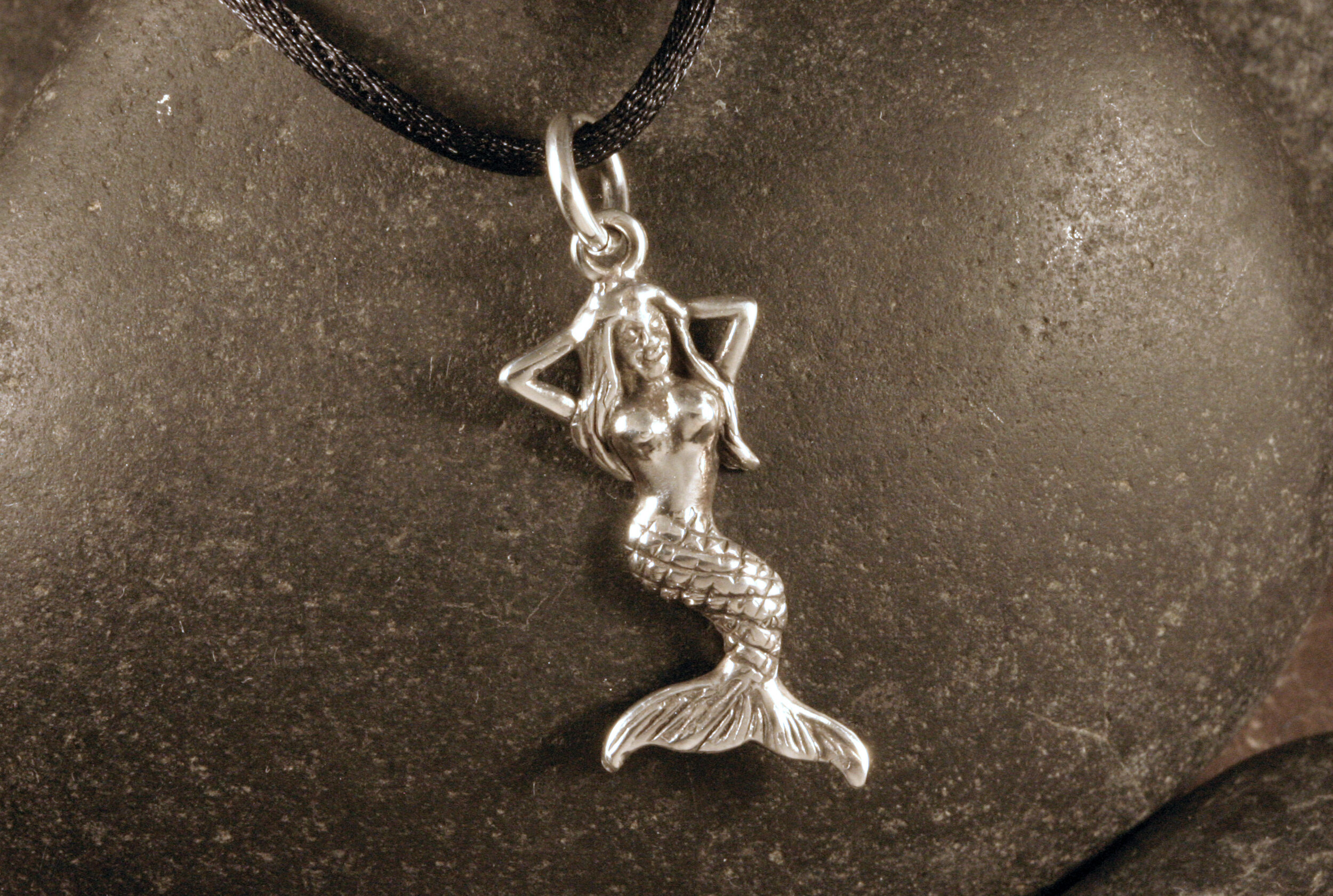 An oxidized sterling silver mermaid charm.