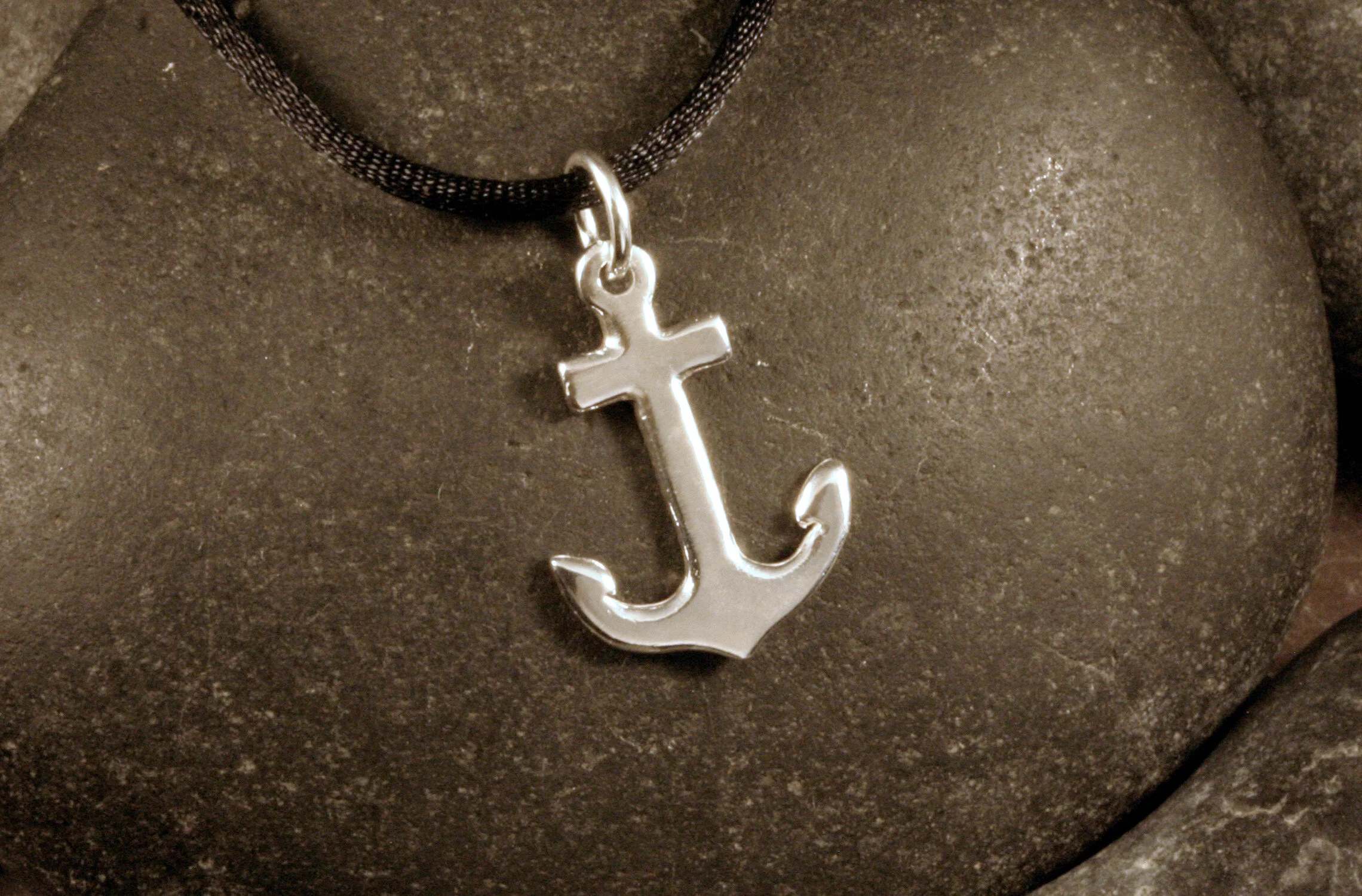 A medium sterling silver anchor charm pendant.