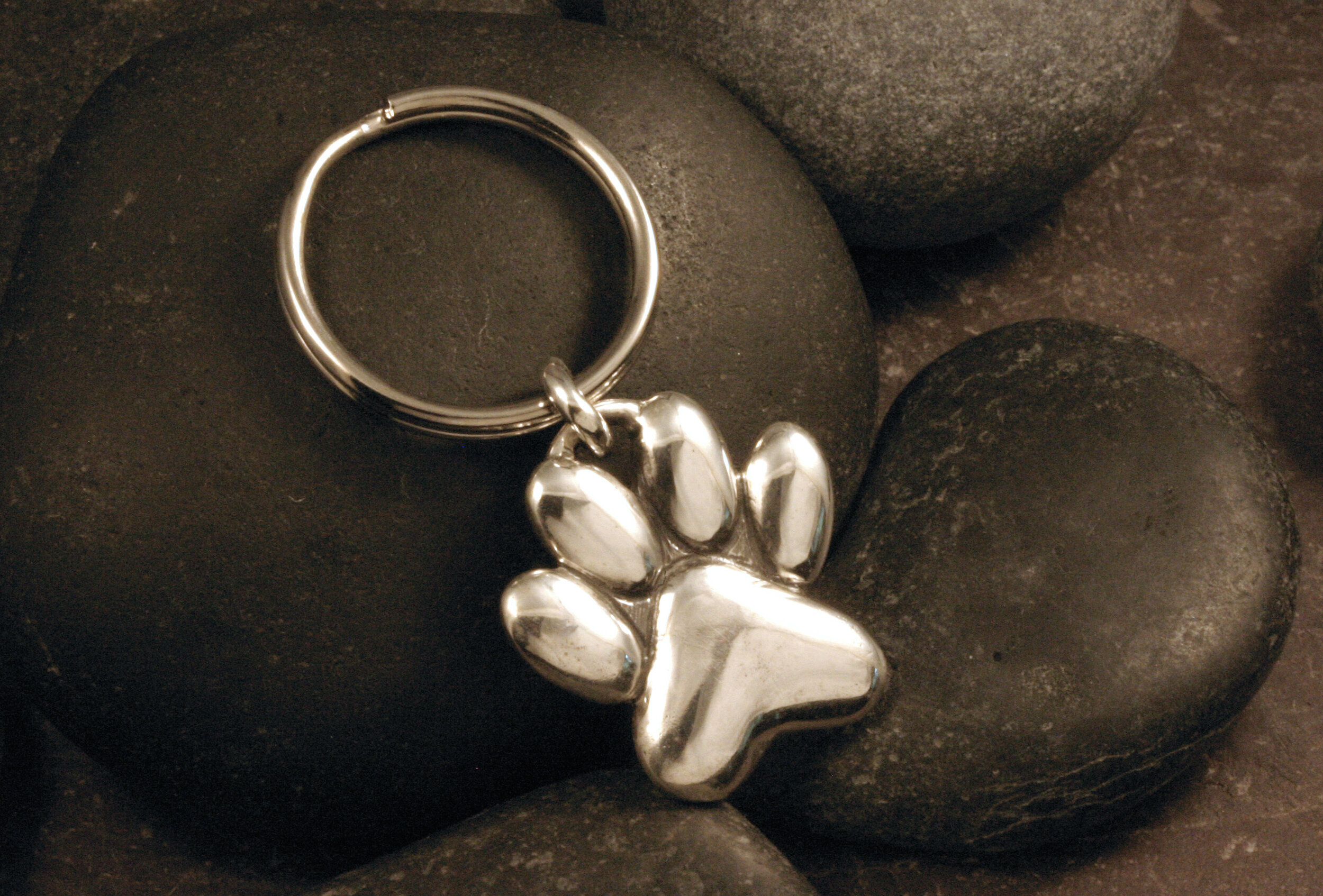 Sterling silver pawprint keychain on an angled view.