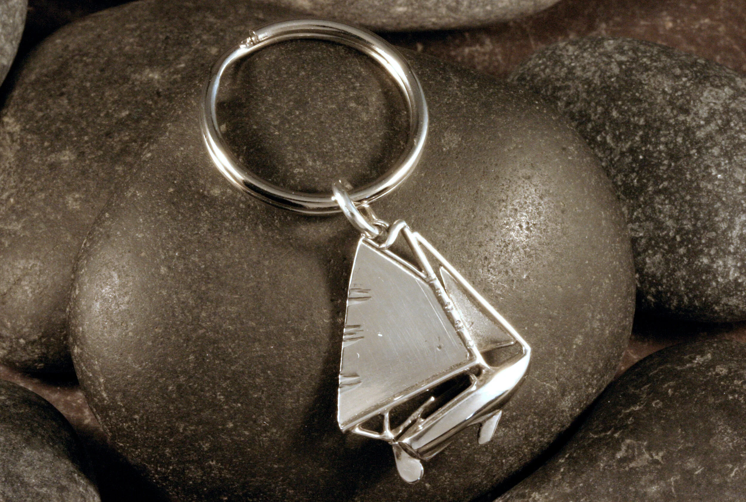 Oxidized sterling silver baybird sailboat keychain with a nickel plated key ring.