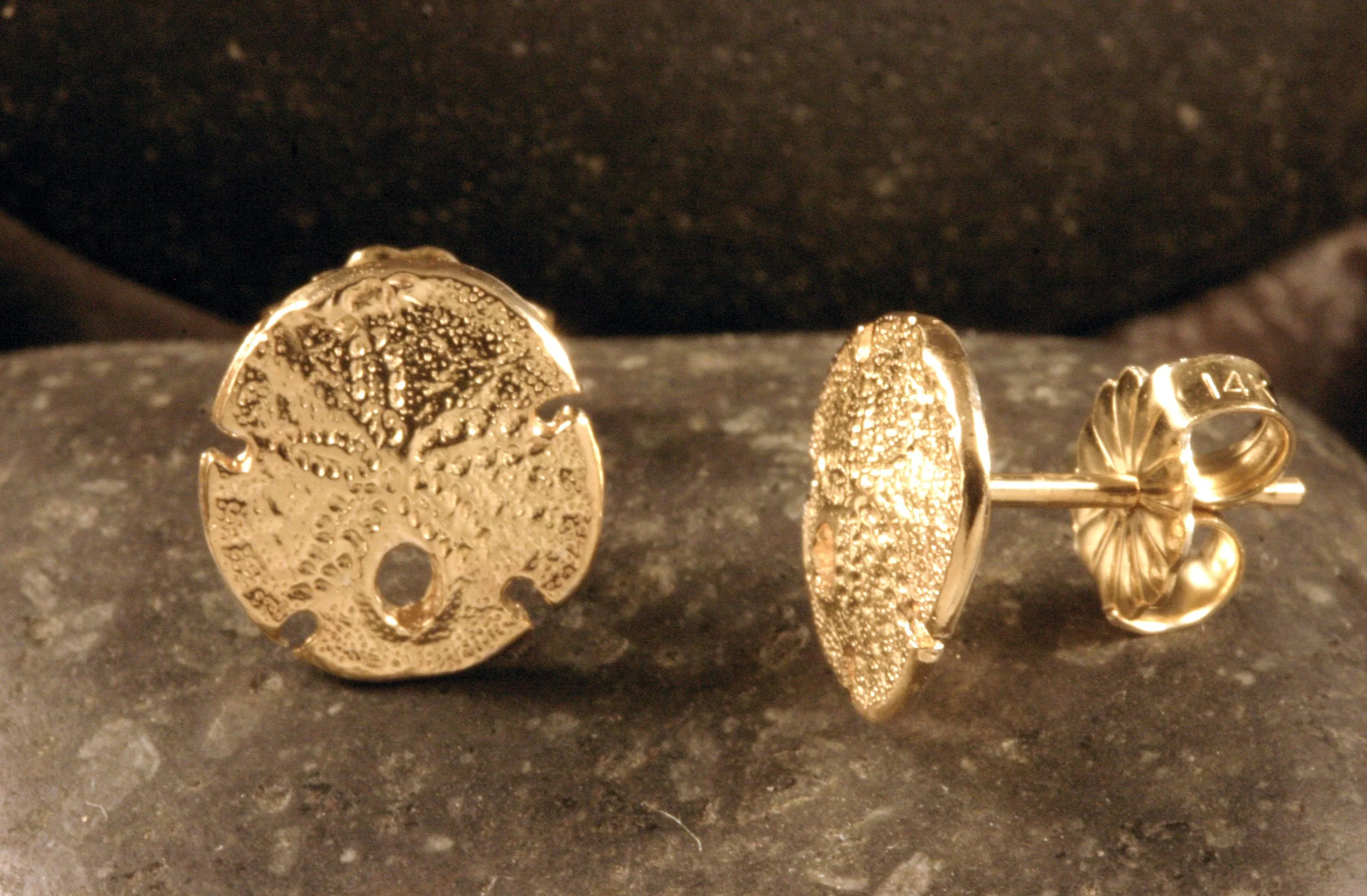 A side view of 14K gold mini sanddollar stud earrings.