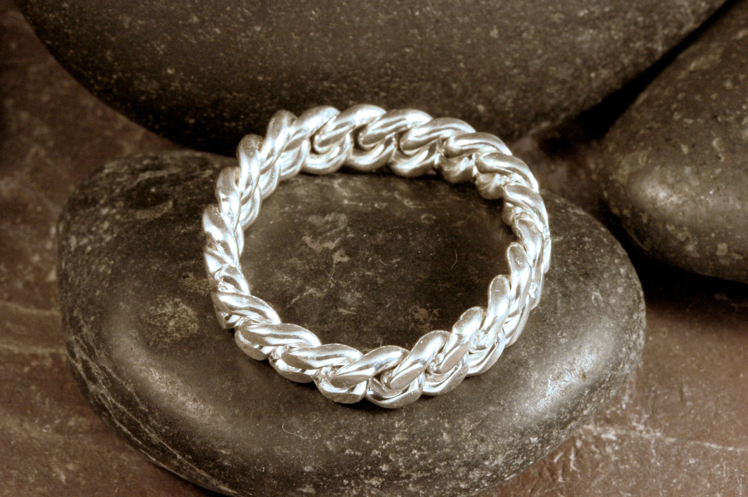 A circle side view of a sterling silver curb chain fidget ring.