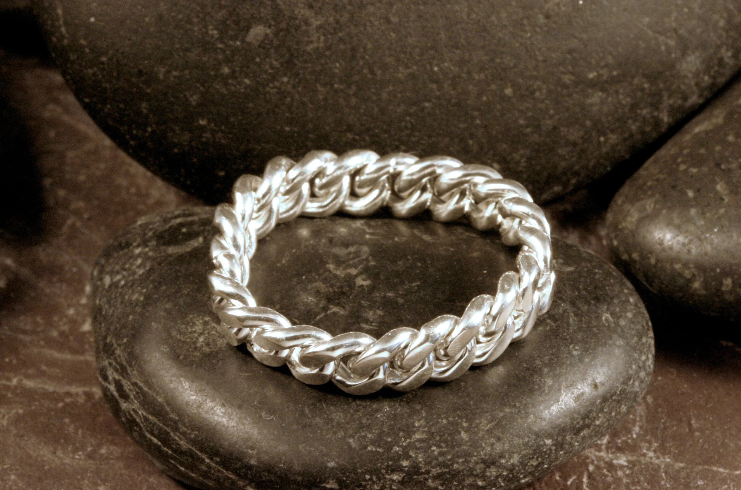 A top view of a sterling silver curb chain fidget ring.