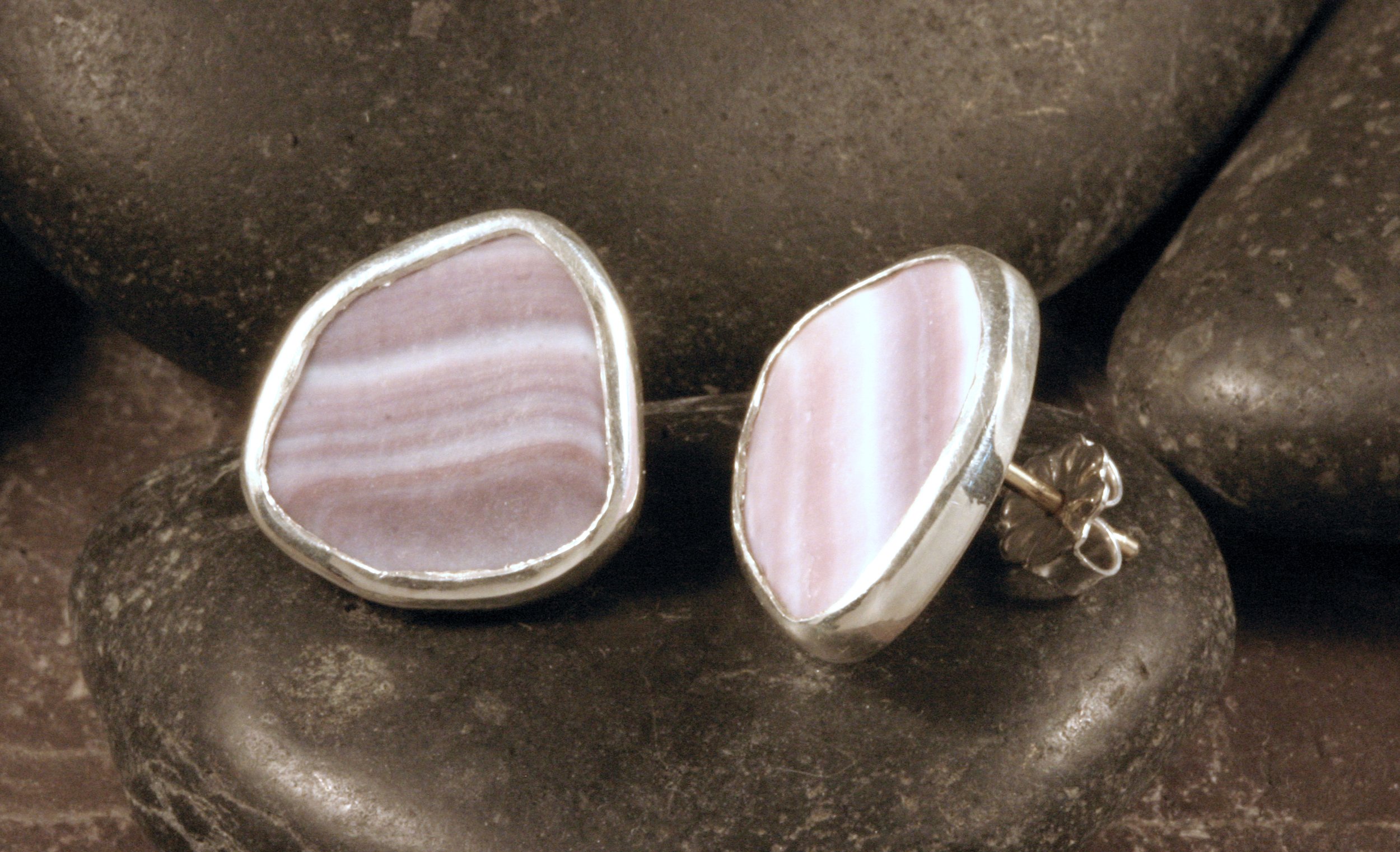 A side view of large sterling silver pentagon wampum stud earrings.