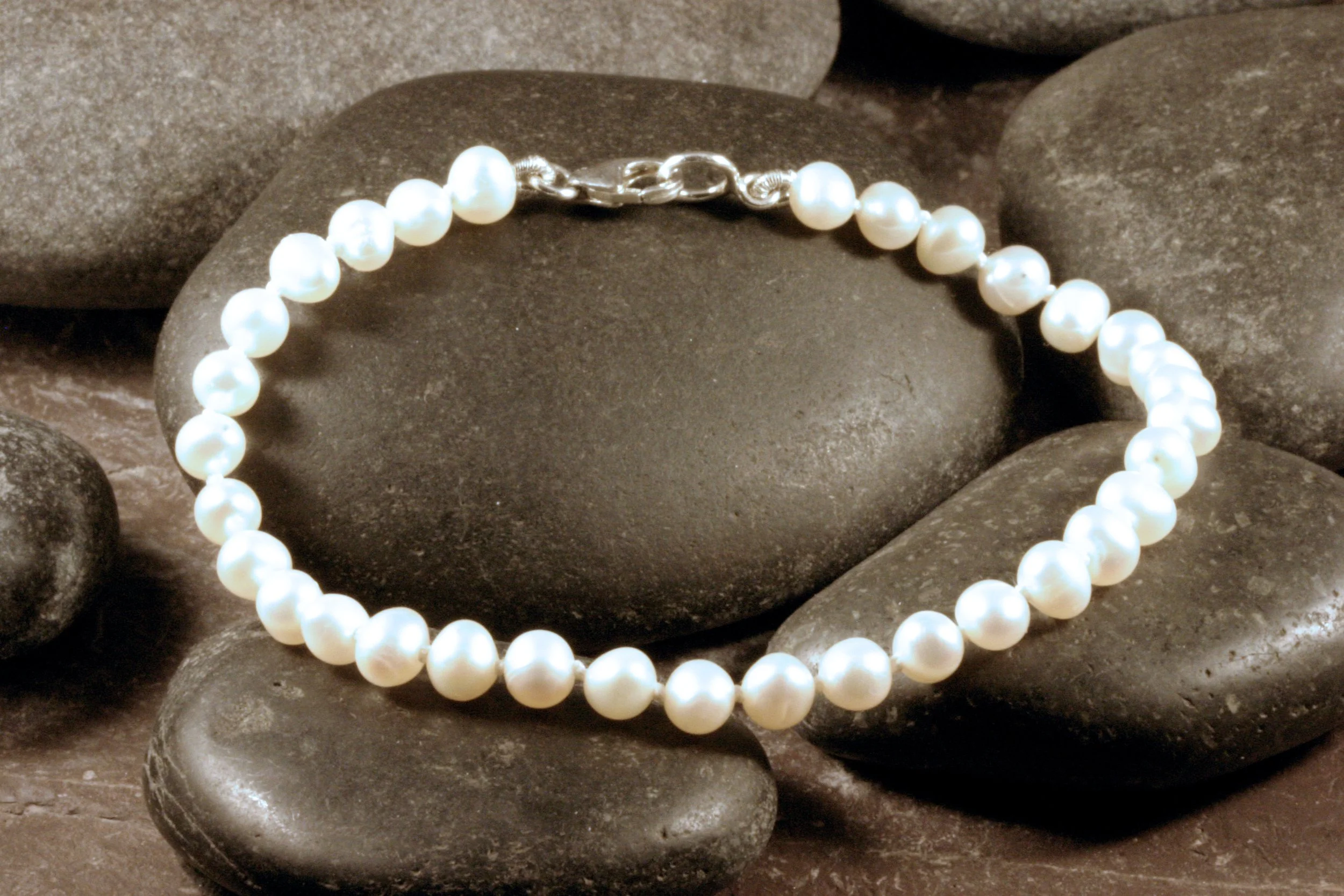 A white freshwater pearl bracelet with a sterling silver trigger lobster clasp.